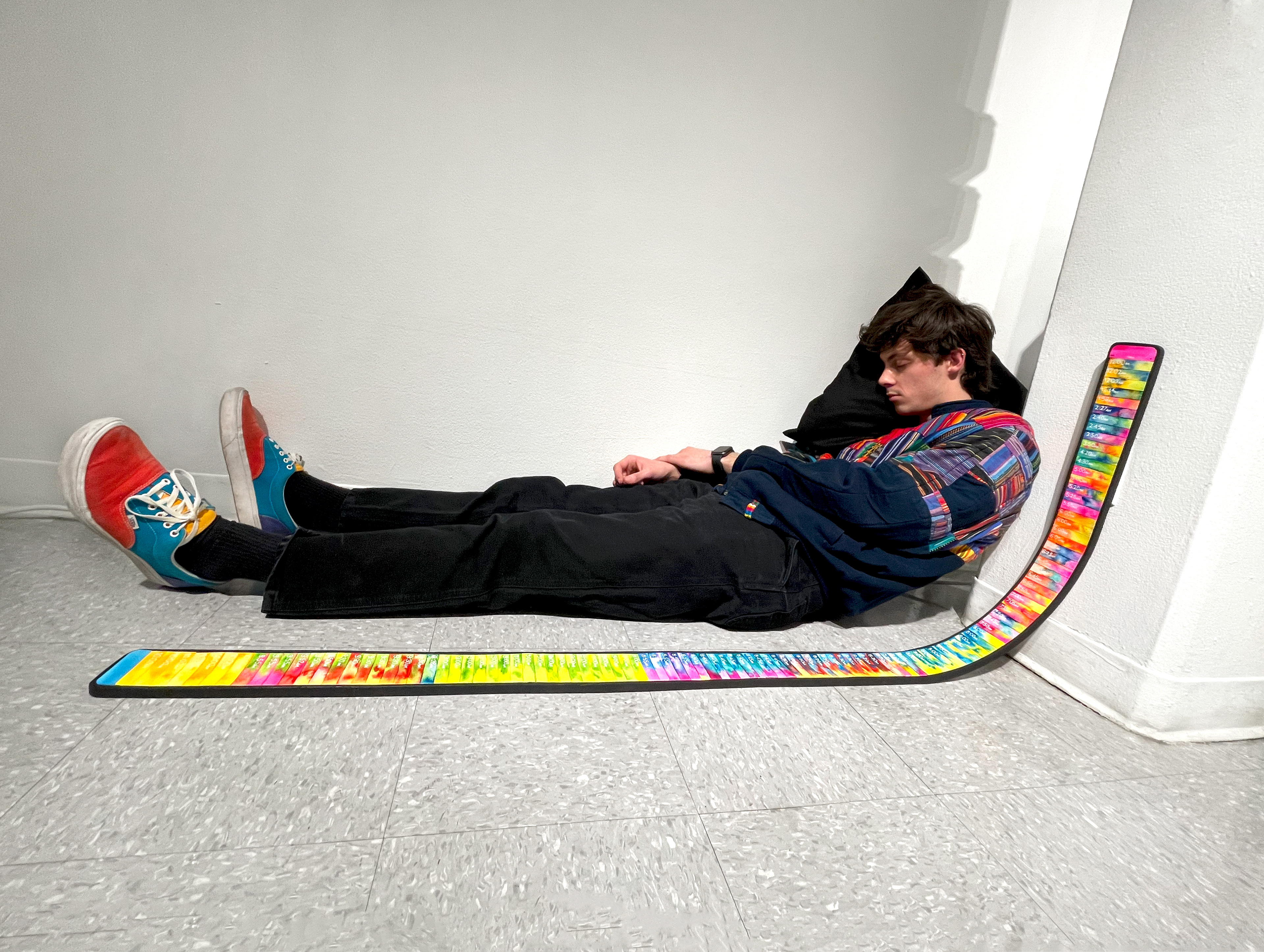 Dustin slouched on the floor, mirroring the 6 foot 2 inches long rainbow iphone full of alarms in the clock app.