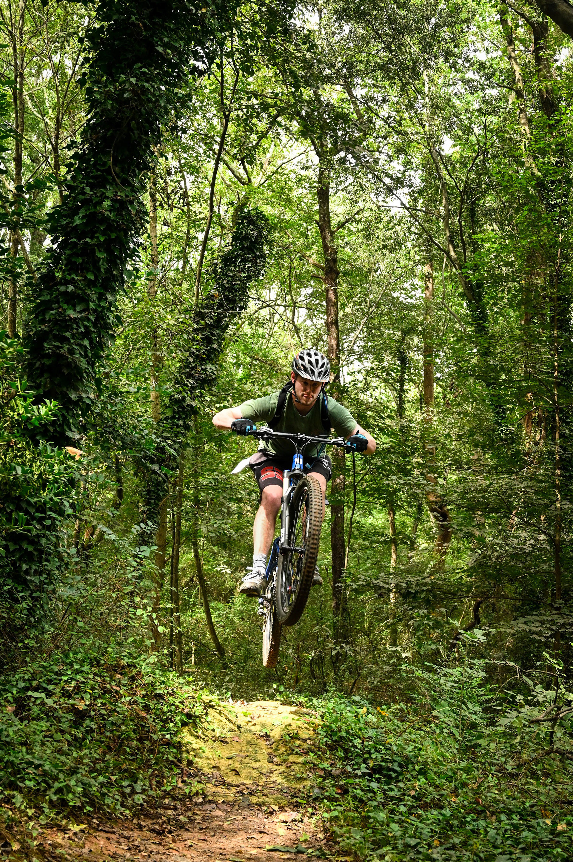 A biker doing a jump in the forest