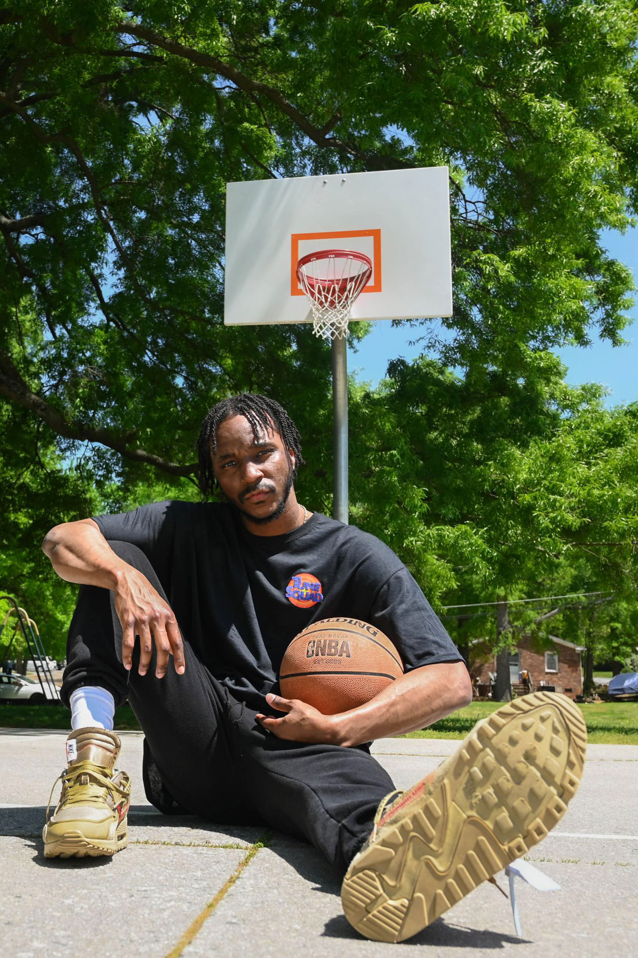 A basketball player posing with a ball and hoop