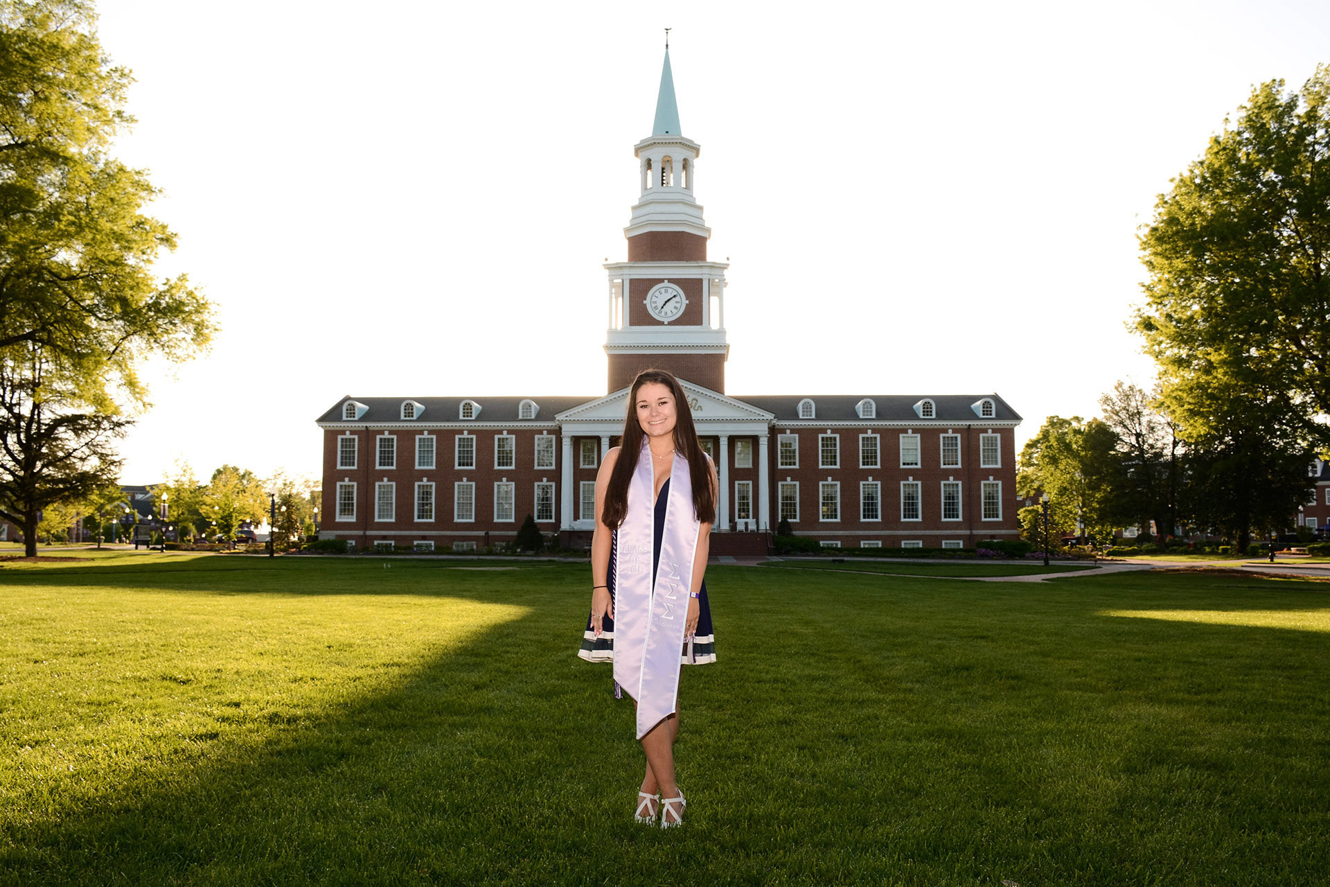 A girl posing in front of Roberts Hall