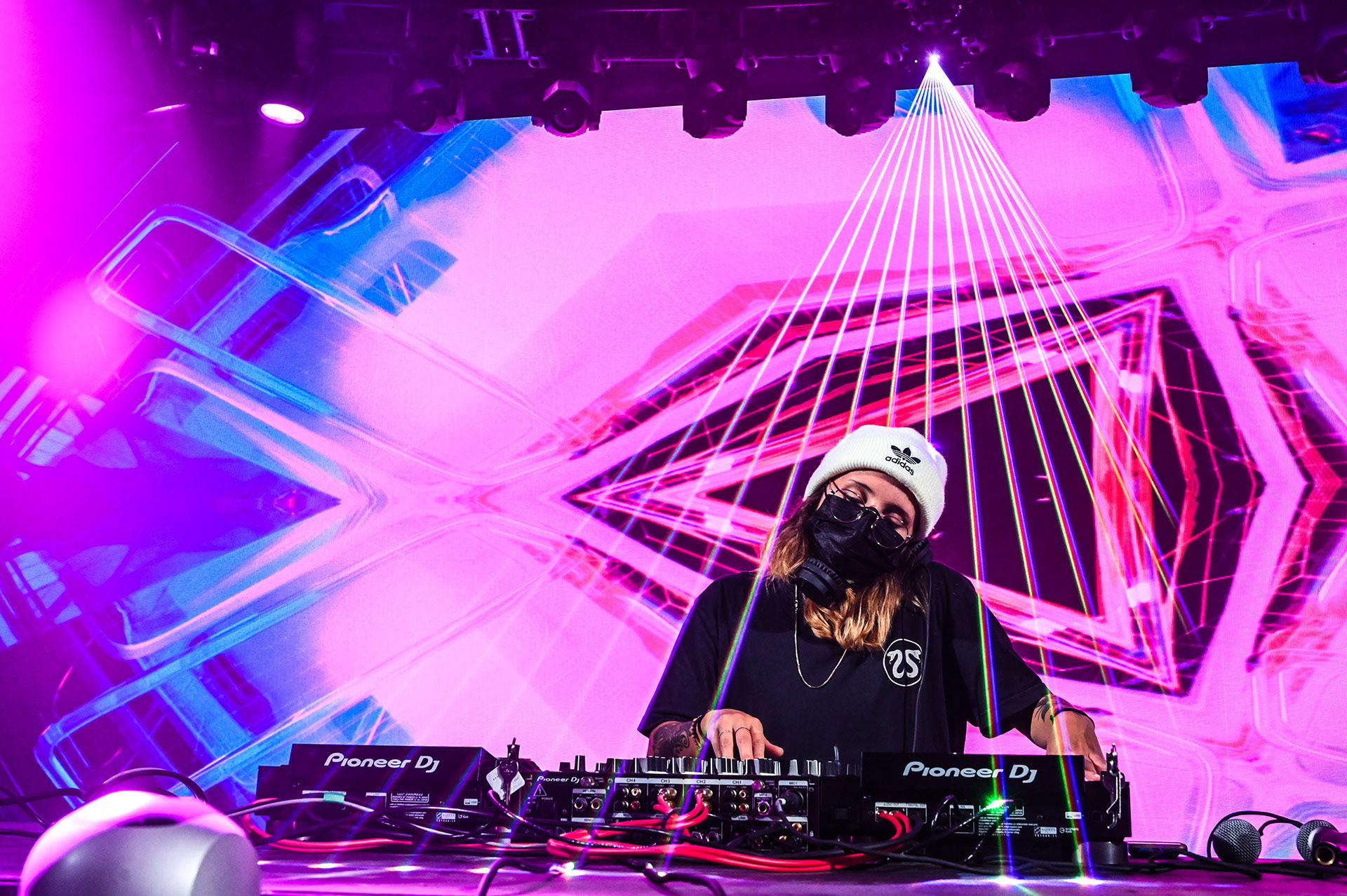 A DJ with lights and lasers all around her