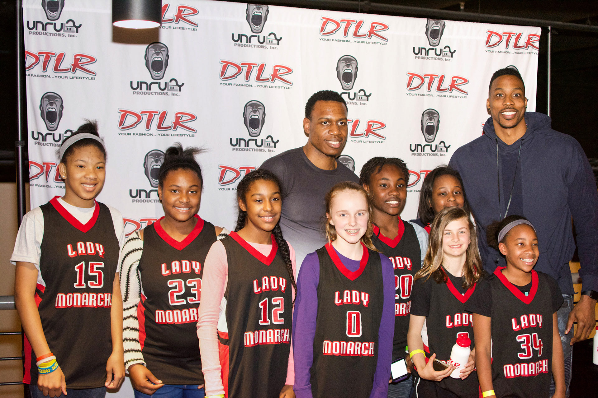 Dwight Howard posing with a girl's youth basketball team