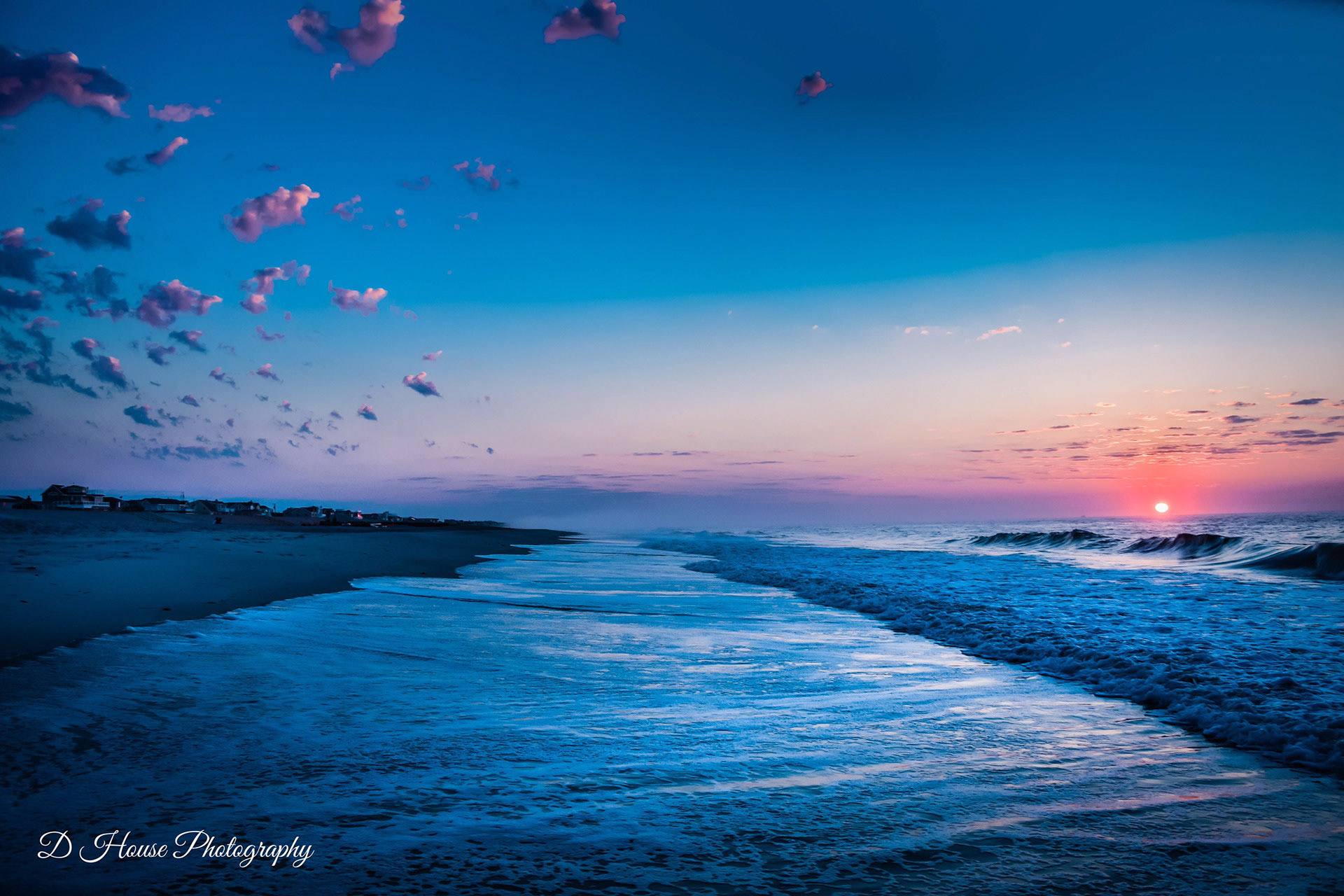 A colorful sunrise on the beach with the waves rolling in