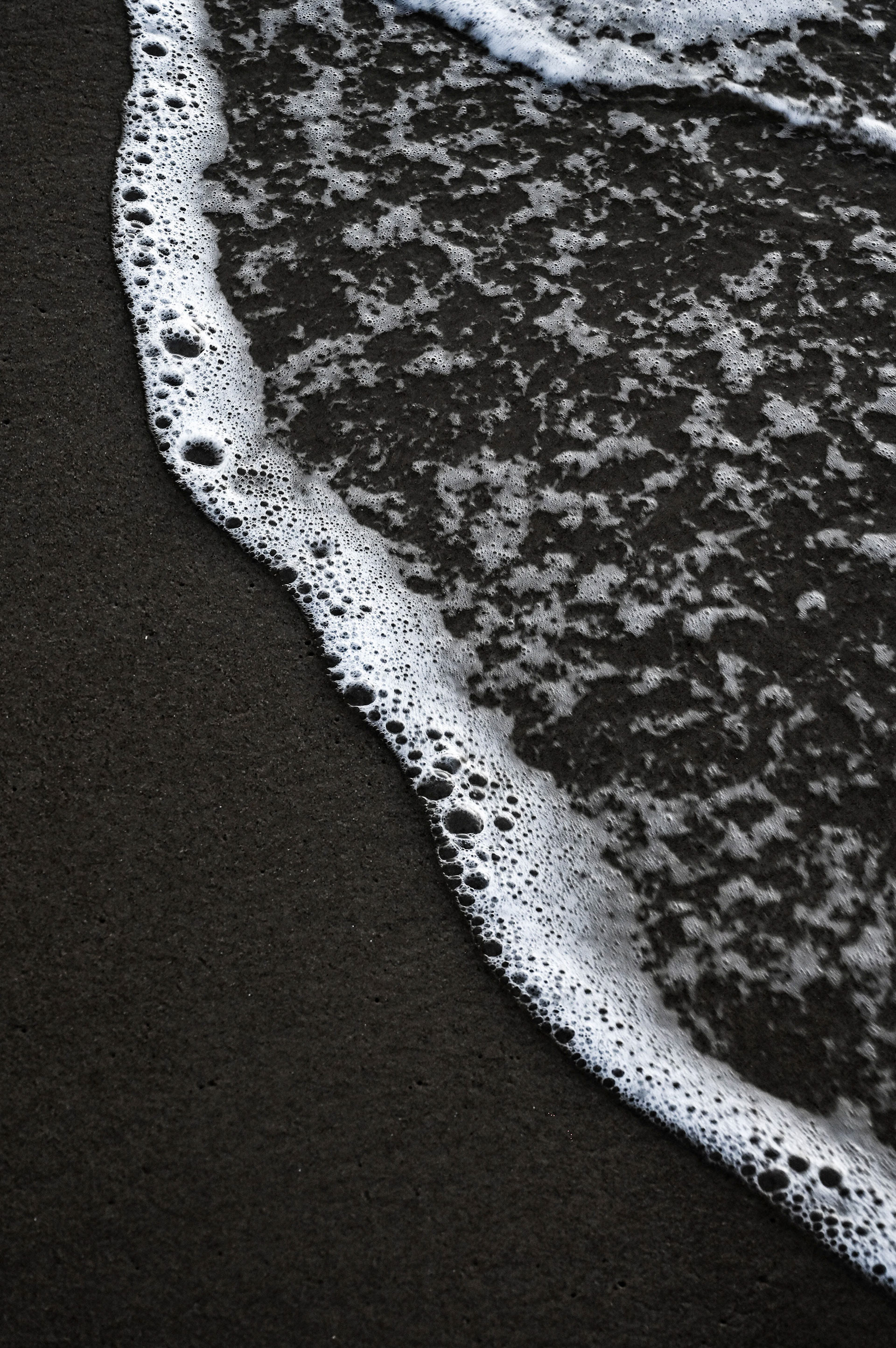 White wash foam rolling on the dark sand beaches