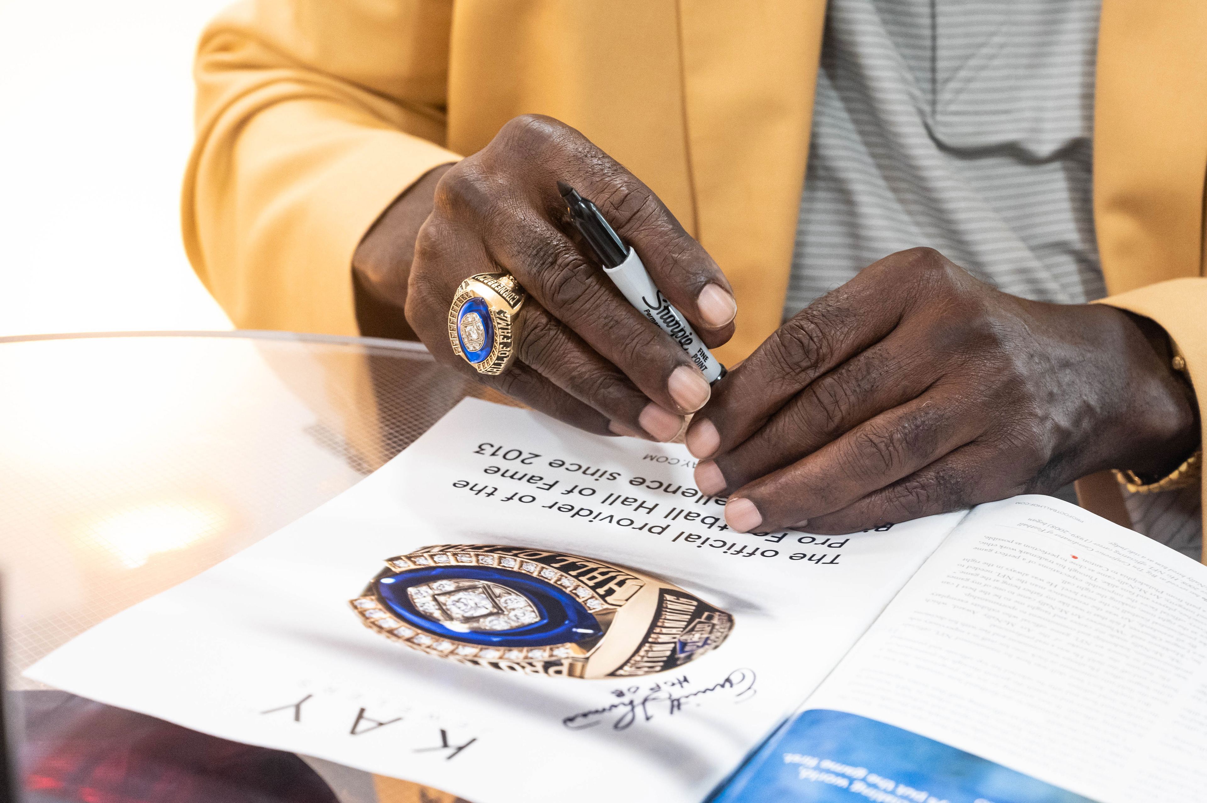 Close up of a Hall of Fame ring in a catelog and on the players finger