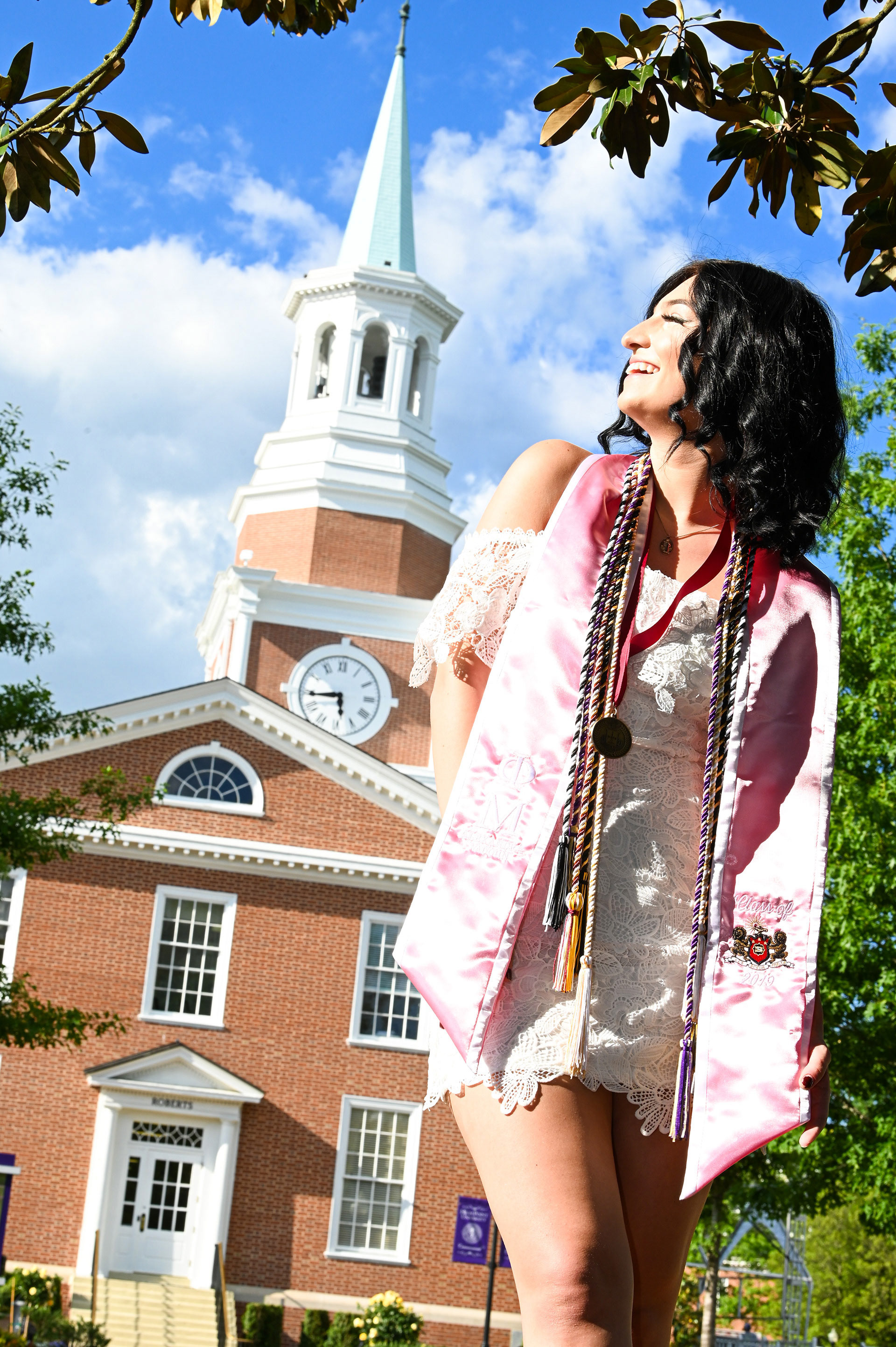 Girl standing under a tree wearing cords and stoles