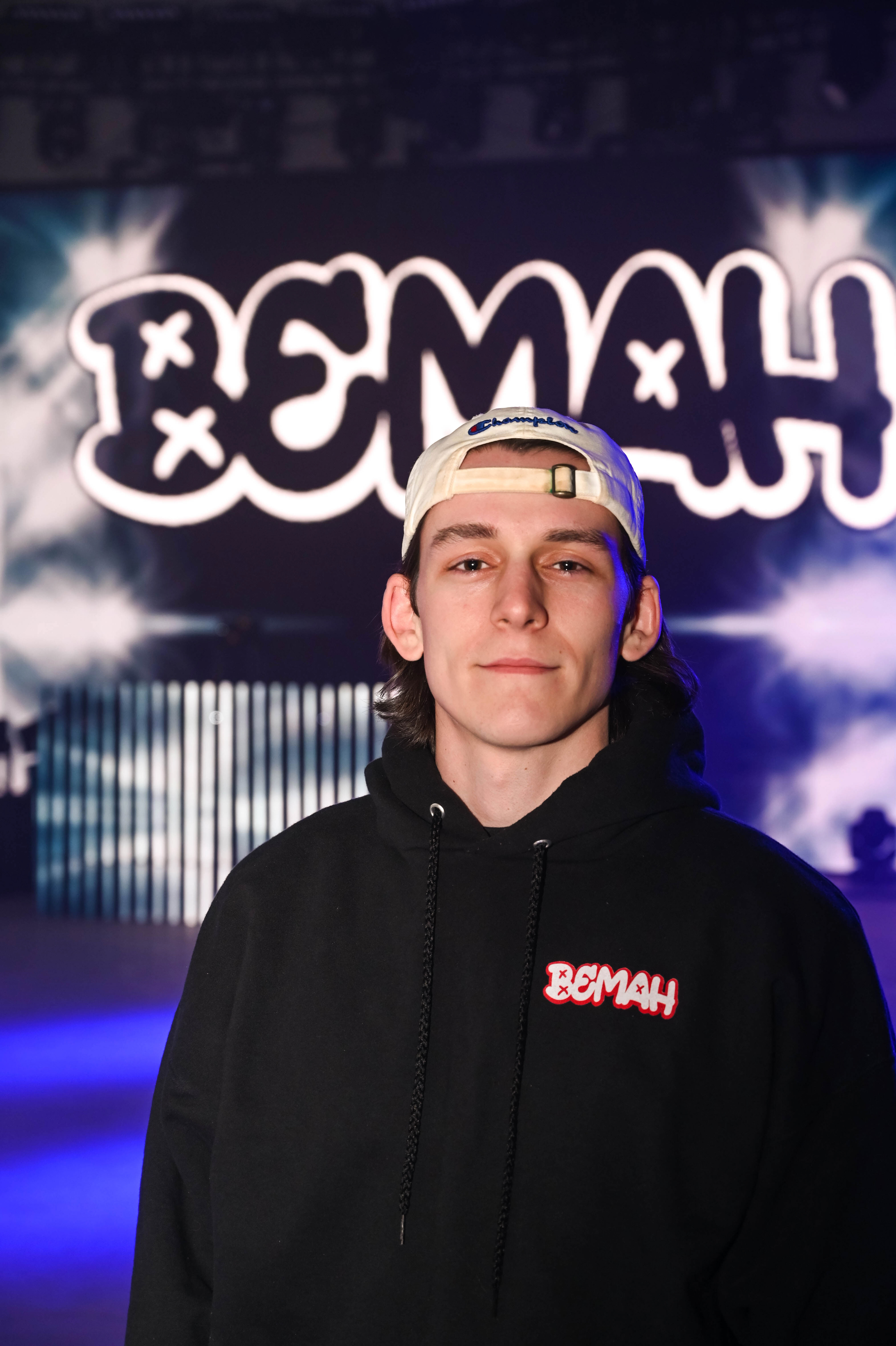 A DJ posing in front of his logo