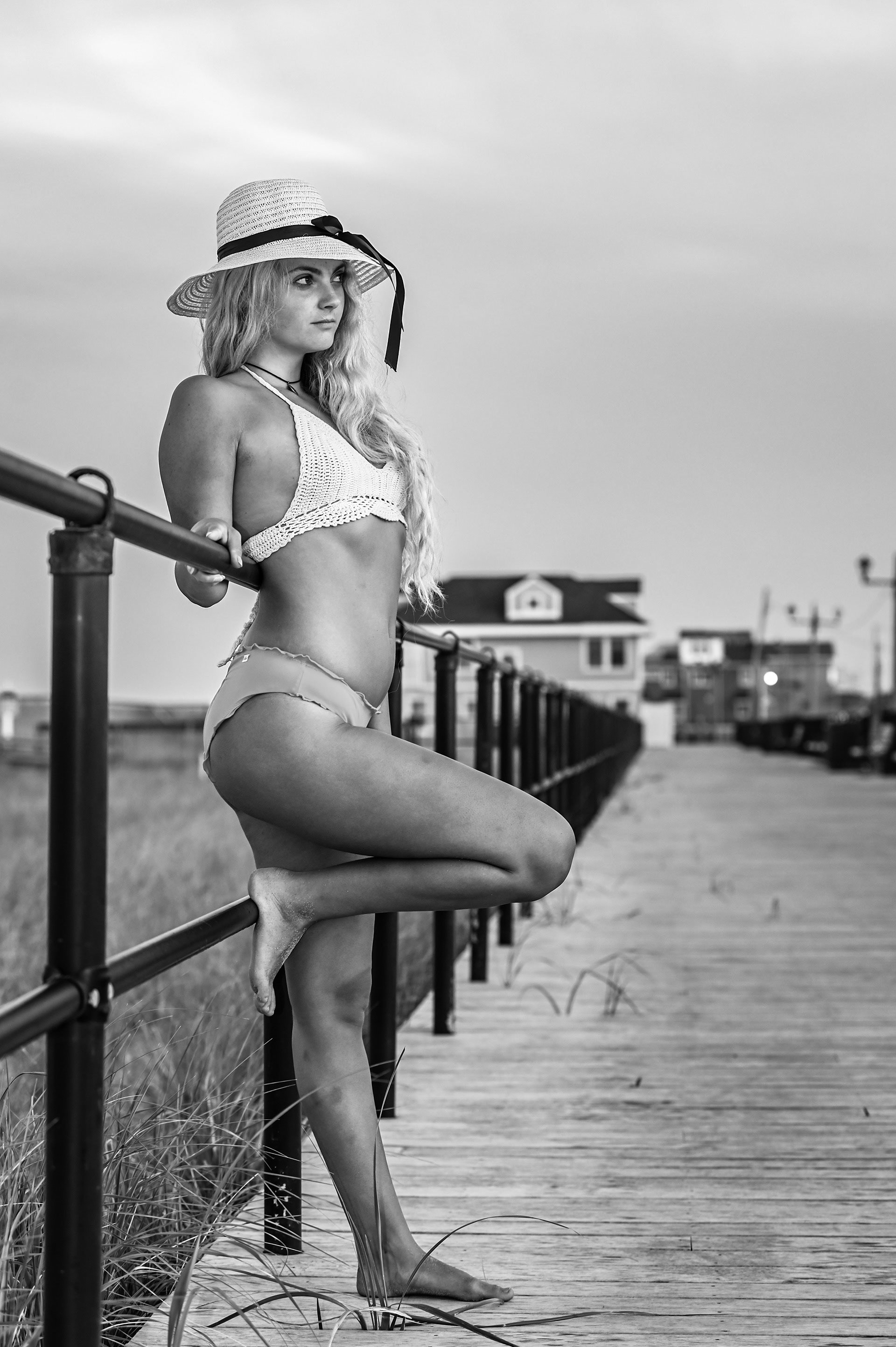 A model standing on the boardwalk in black and white
