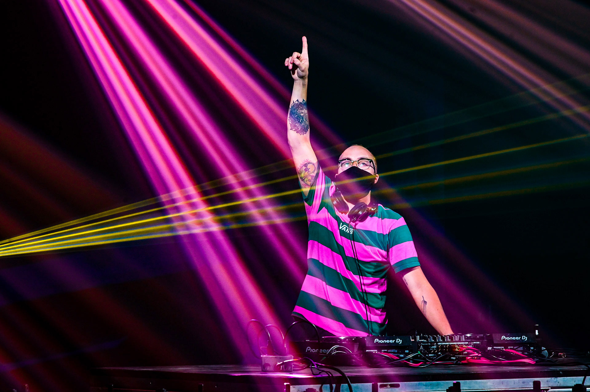 DJ pointing to the sky with lasers coming down
