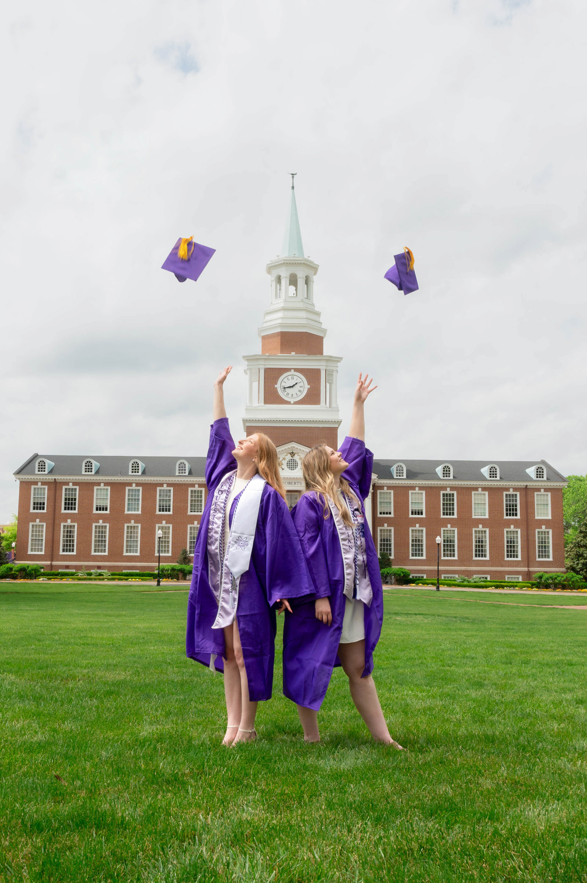 Two girls throwing their caps in the air