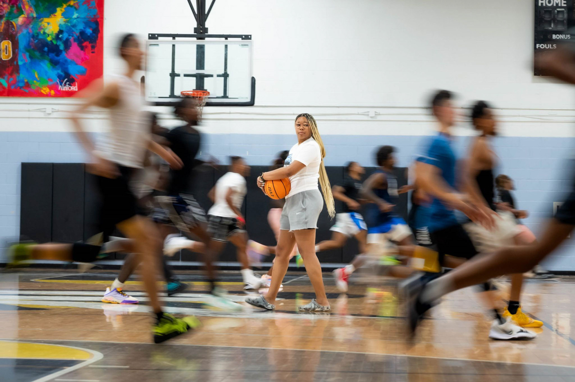 A coach watches her team run during try outs