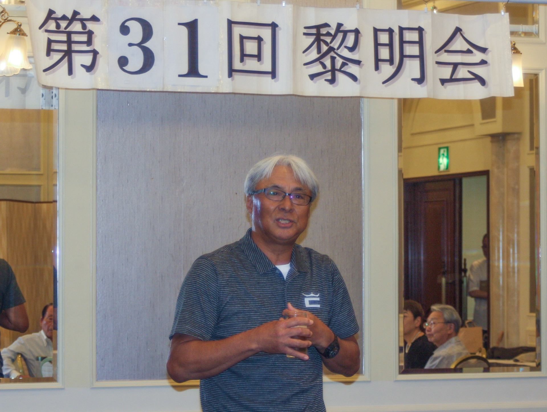 頭は白く顔は黒い宮本会長の挨拶