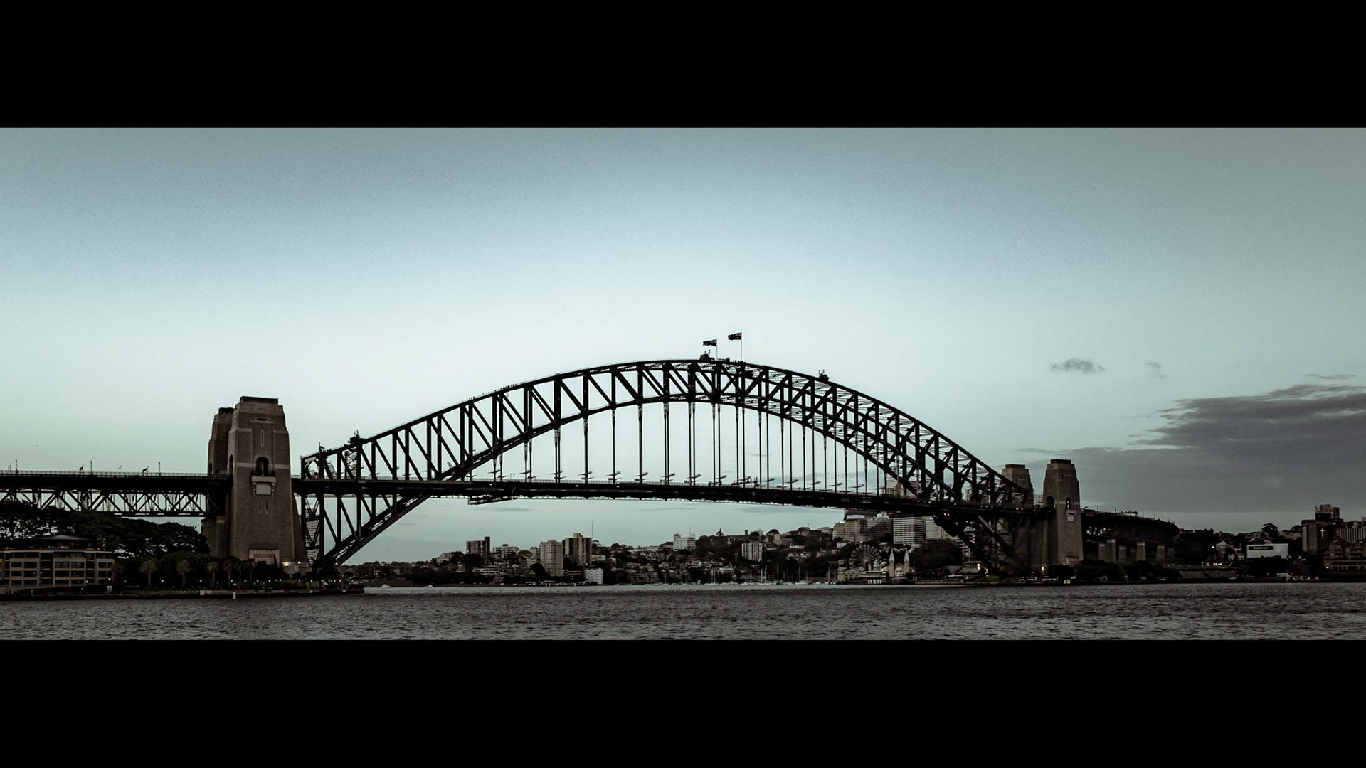 Beyond-anamorphic crop for a photo? Why the hell not!? 🙂 Anyway! Here's a photo of the Sydney Harbour Bridge taken just after sunset. Oh and, see if you can find the people walking at the top (and I mean on top of the arch) of the bridge. 😉