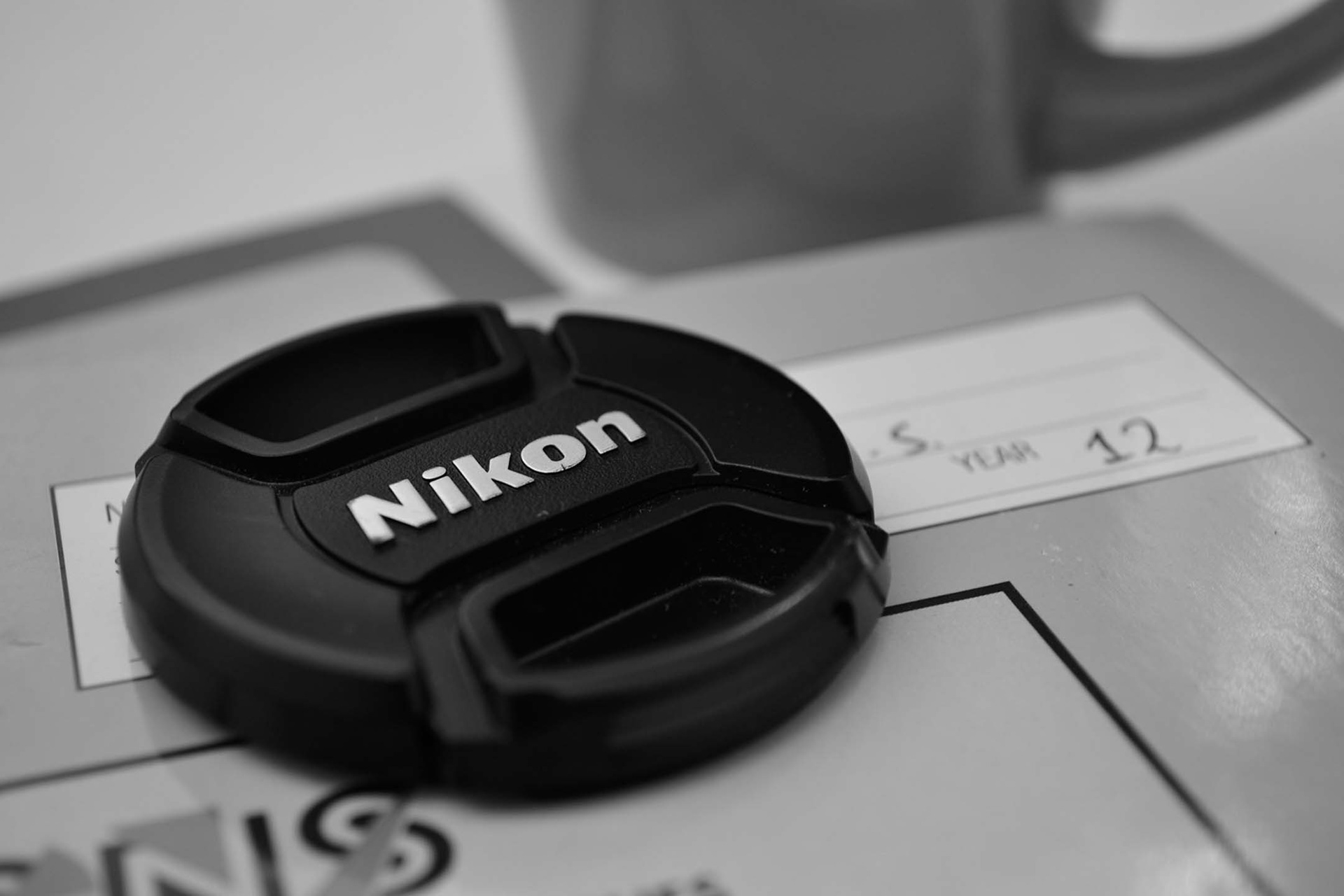 The first ever picture of my portfolio; showcasing my use of my dad's Nikon D3100 with a photo of its lens cap.