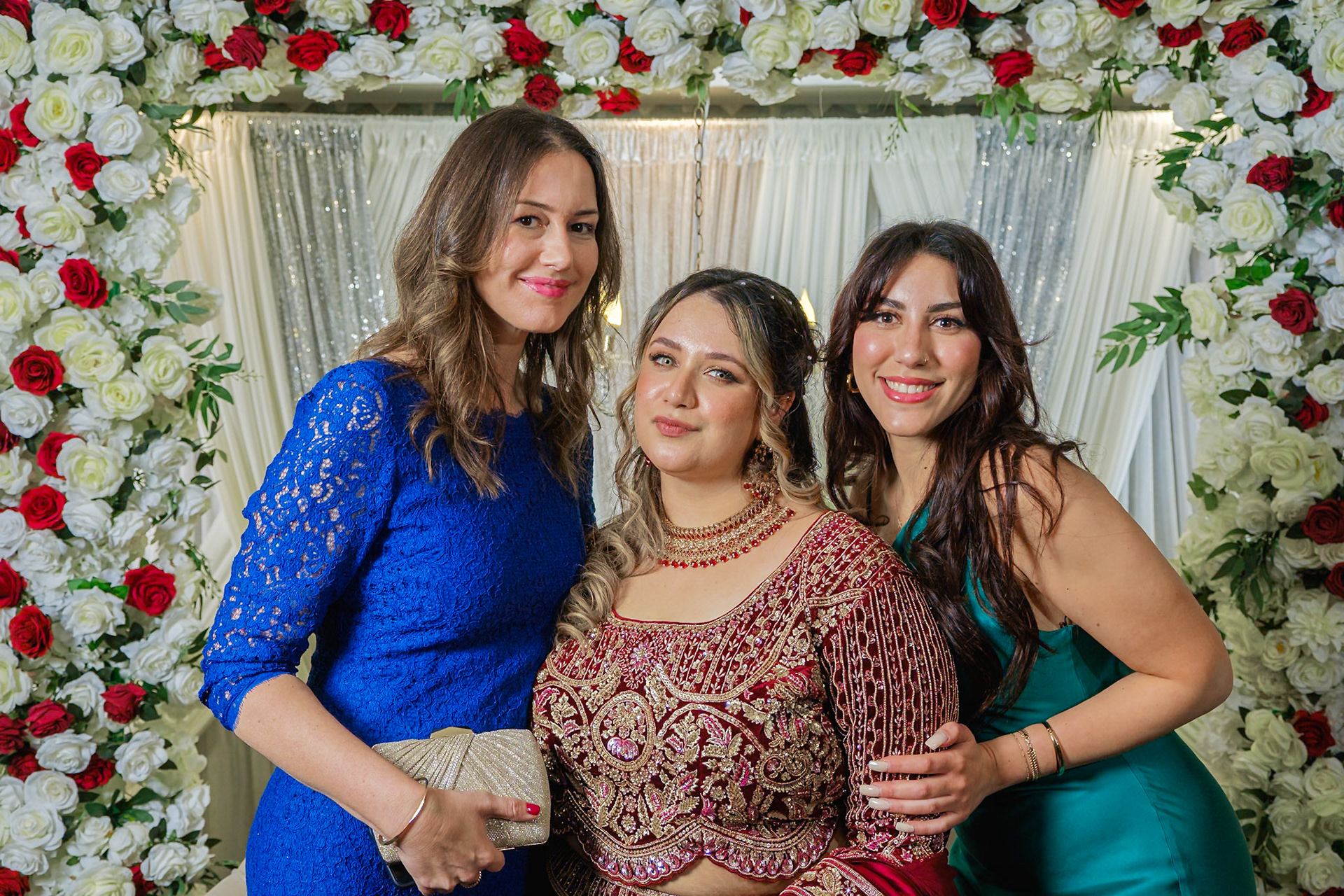 Bride posing with friends against luxurious rose-filled backdrop at Toronto engagement party, lifestyle event photography