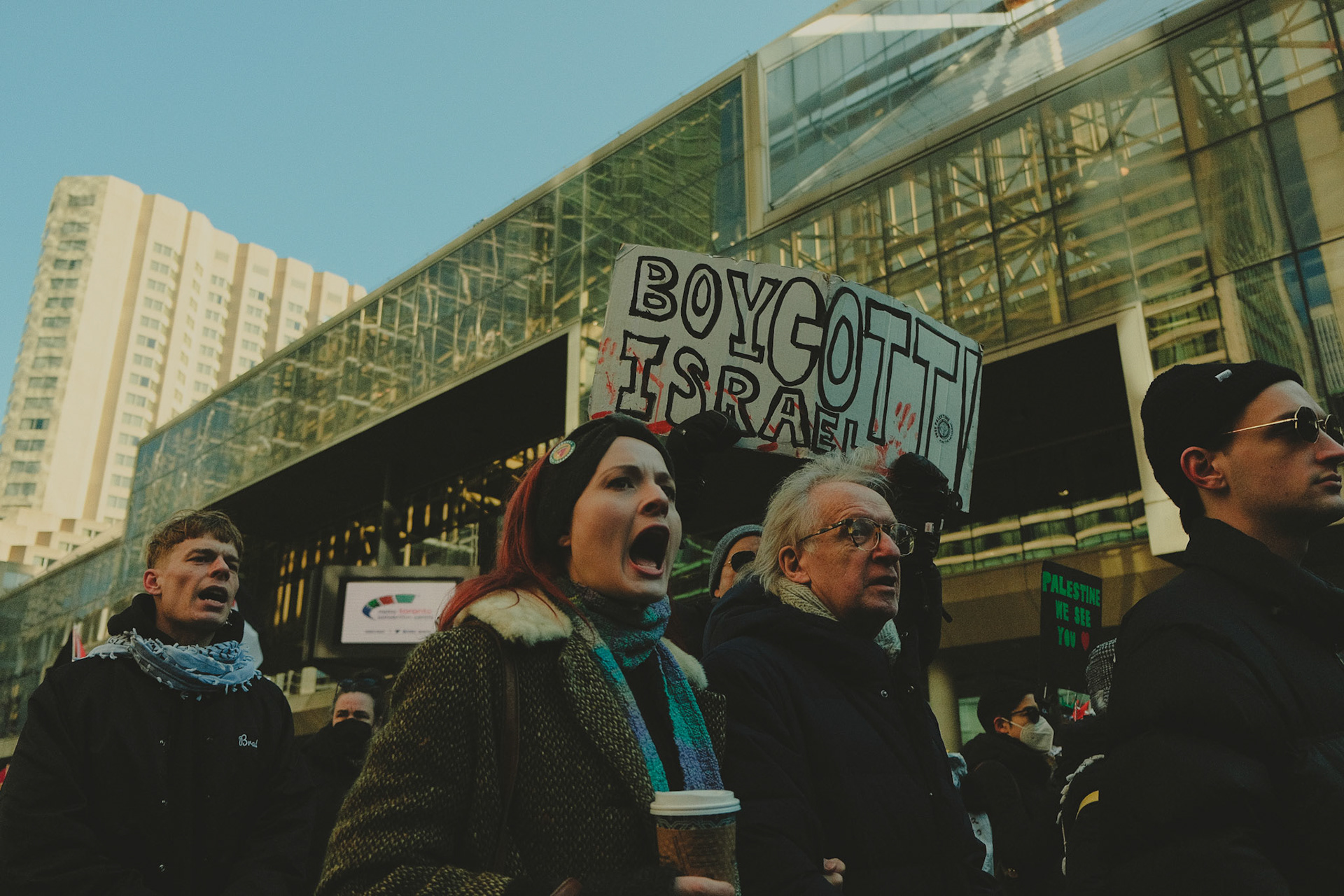 Close-up of a passionate Pro-Palestine protester in Toronto, raising a sign and chanting against war crimes in the Israel-Palestine conflict. Emotion and activism in urban photography.