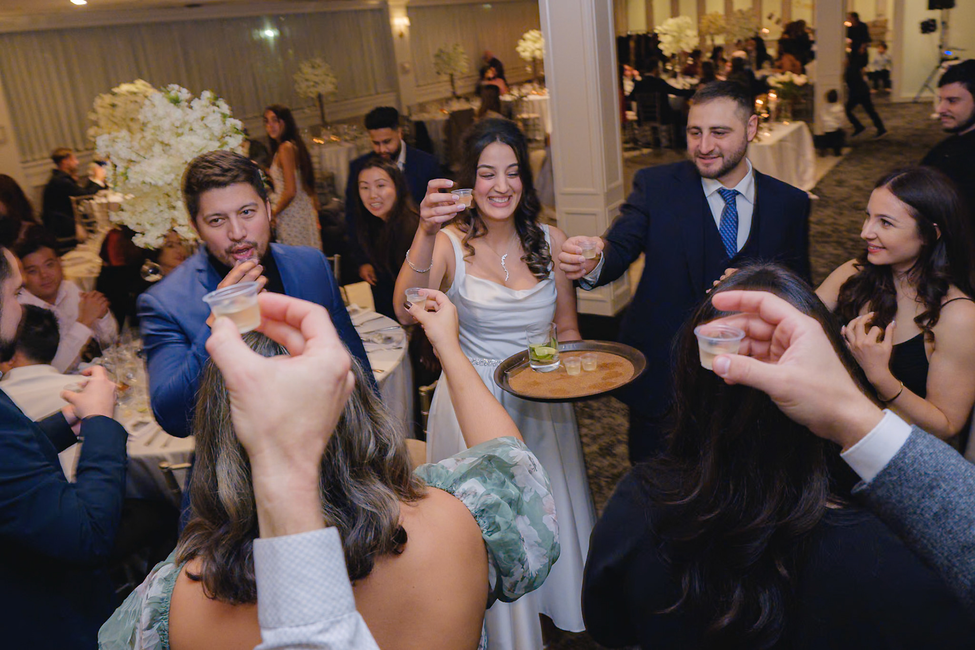 Guests raising tequila shots in unison during engagement party toast in Toronto