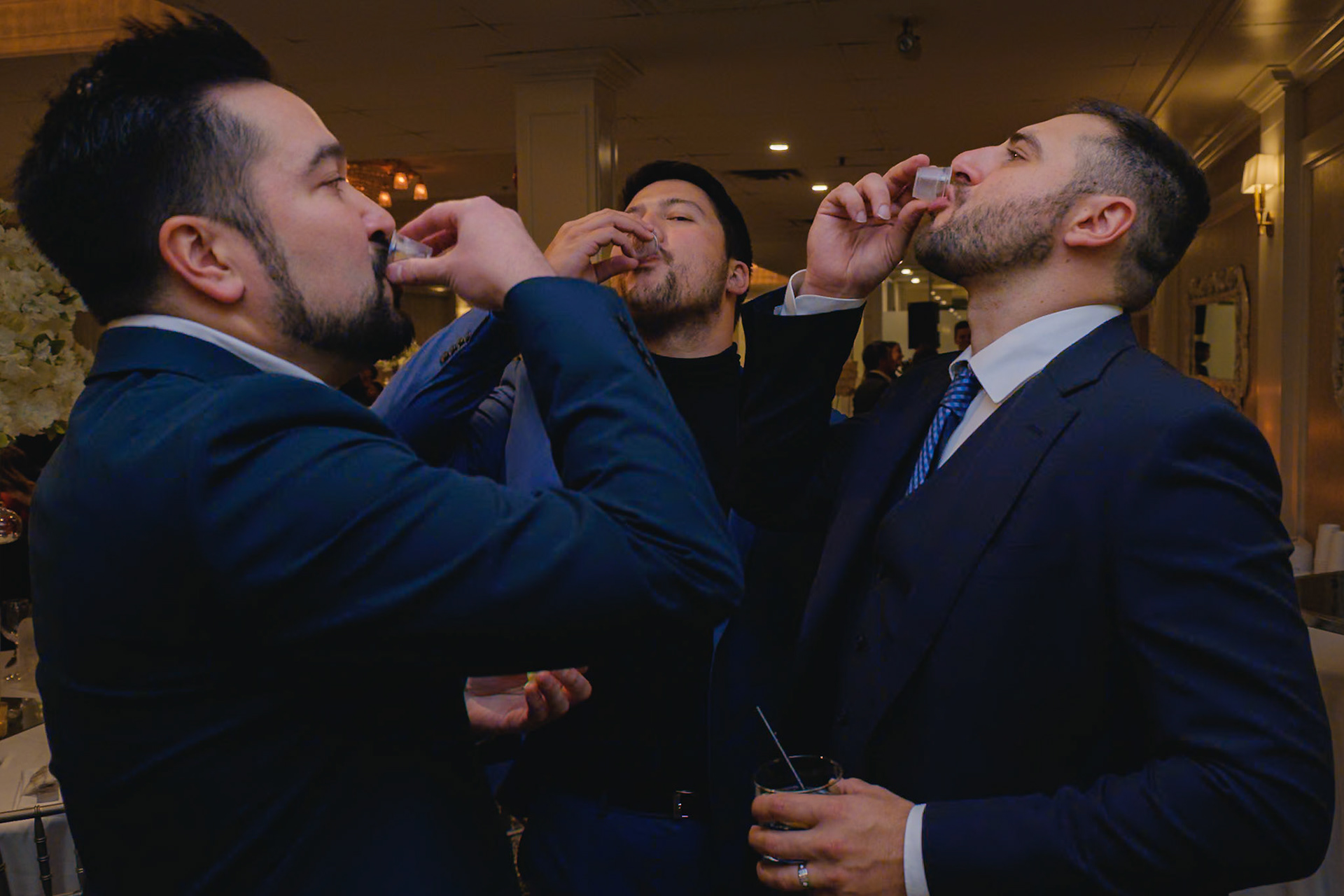 Groom and groomsmen taking celebratory shots at Toronto engagement party, candid moment captured by Cristian Arango