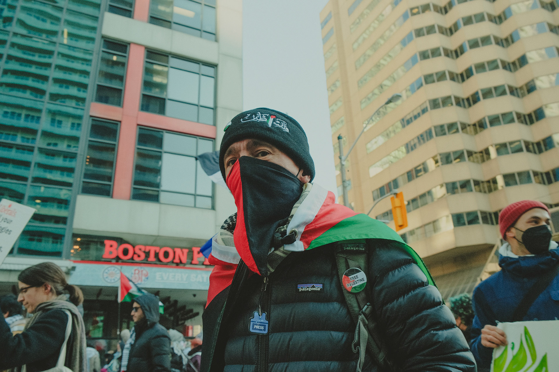 Close-up of a passionate Pro-Palestine protester in Toronto, raising a sign and chanting against war crimes in the Israel-Palestine conflict. Emotion and activism in urban photography.