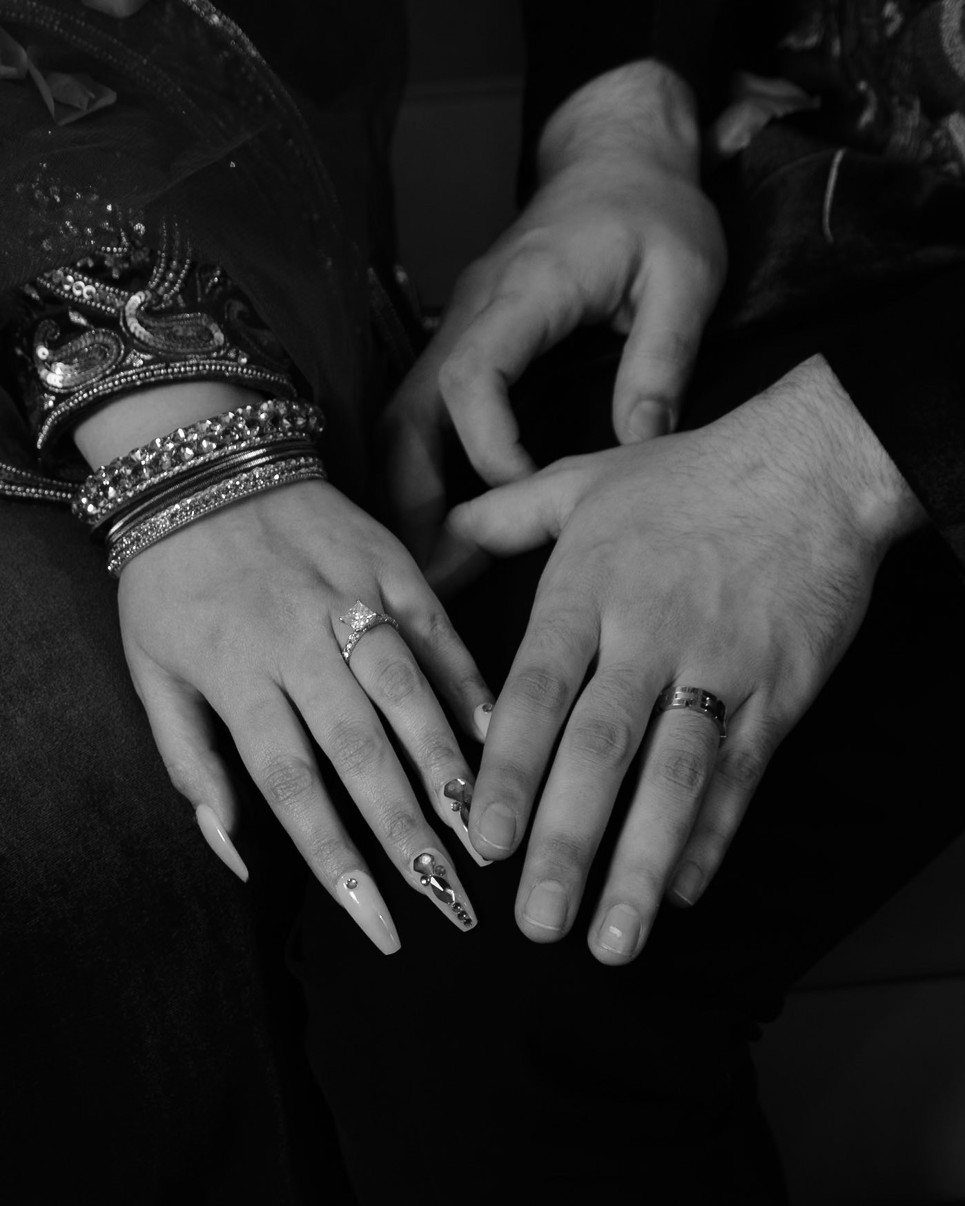 Intimate black and white close-up of engaged couple's hands with rings, photographed at South Asian engagement in Toronto