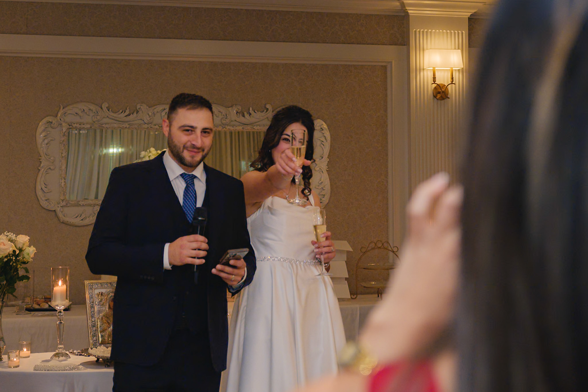 Bride and groom addressing guests with drinks in hand during an engagement toast in Toronto