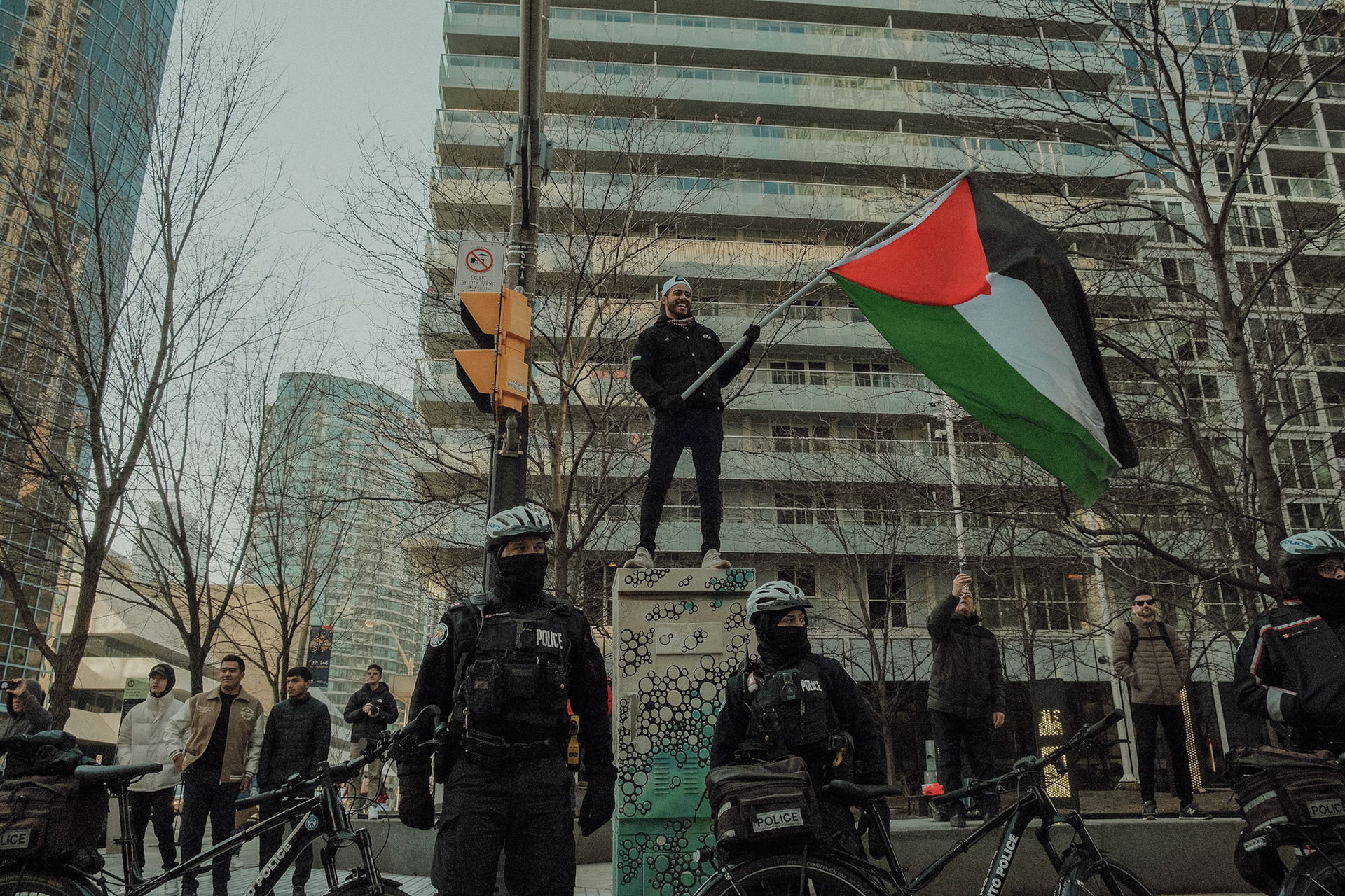 Police officers overseeing a Pro-Palestine demonstration in Toronto, ensuring crowd control during the protest against Israel-Palestine war crimes. Documenting tension and authority