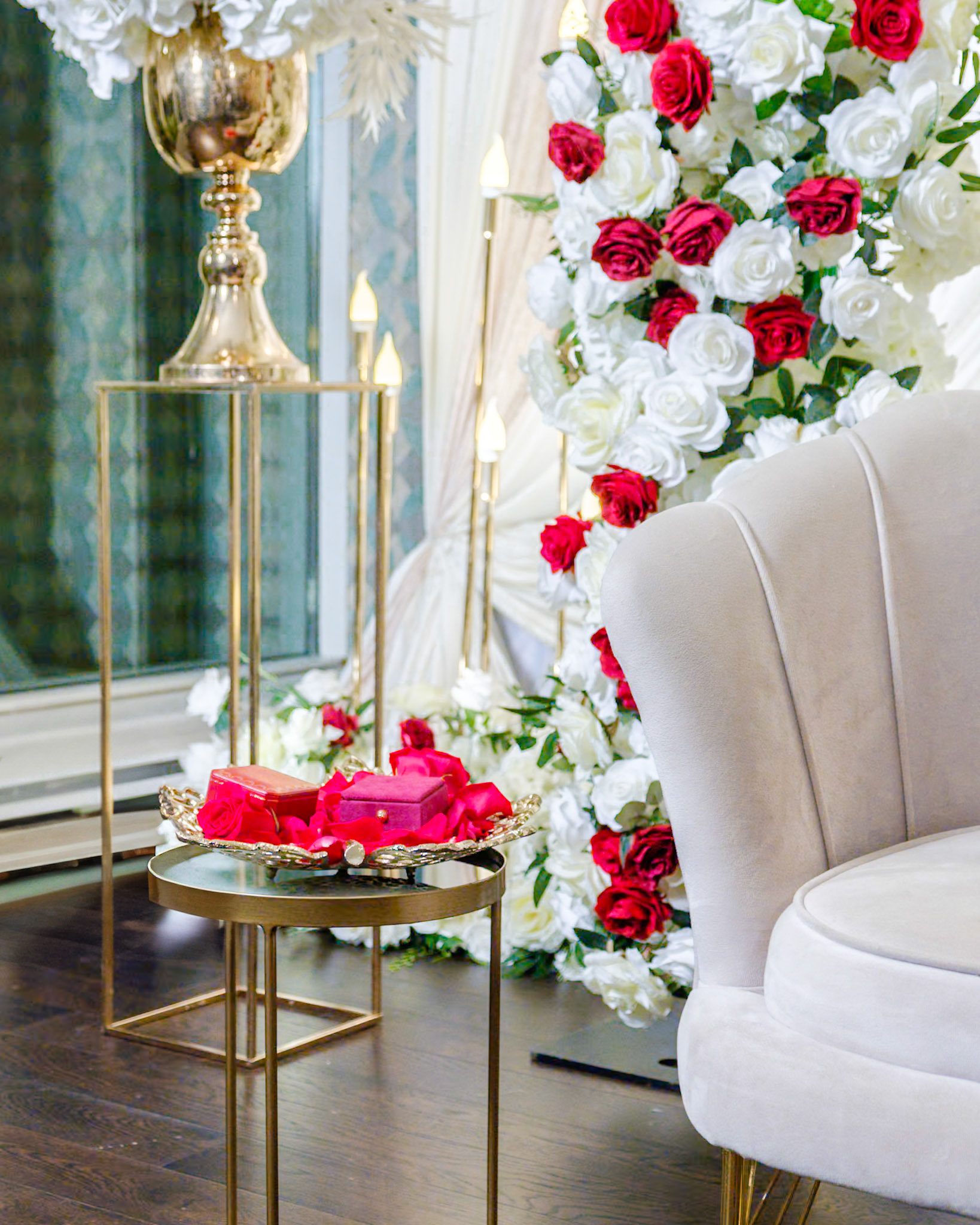 Close-up of ornate gold decor and rose bouquet on side table at Toronto engagement party with South Asian influence