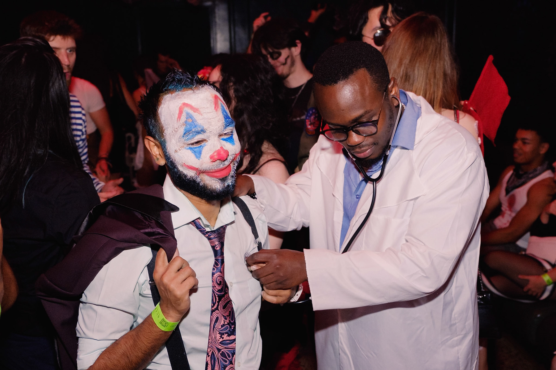 Guests in costume dancing under dramatic lighting at a Halloween party in a Toronto nightclub