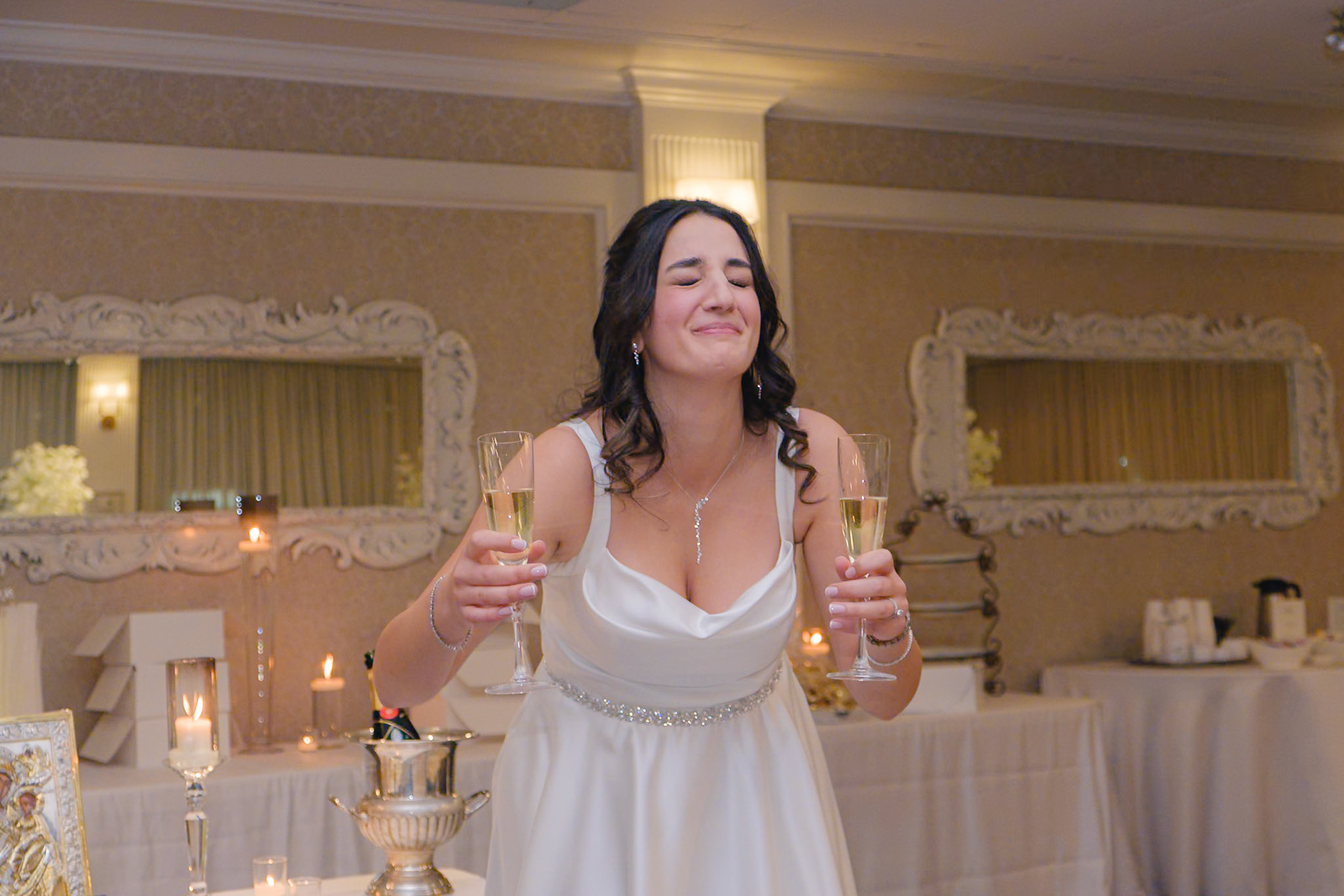ride toasting with champagne and smiling in front of a decorated dessert table during engagement party