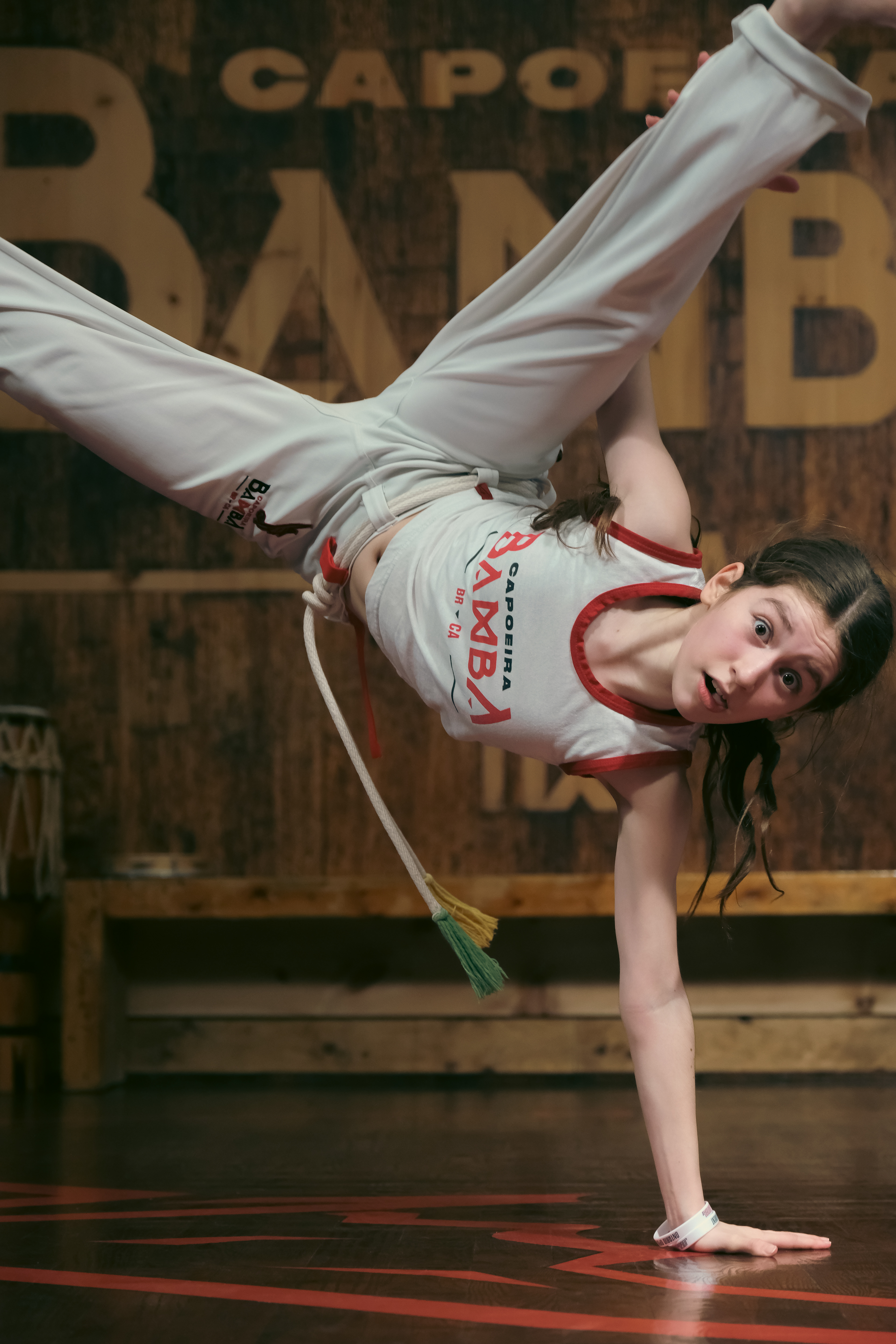 Capoeira performer holding a handstand in mid-air during a roda at Capoeira Bamba, Toronto.