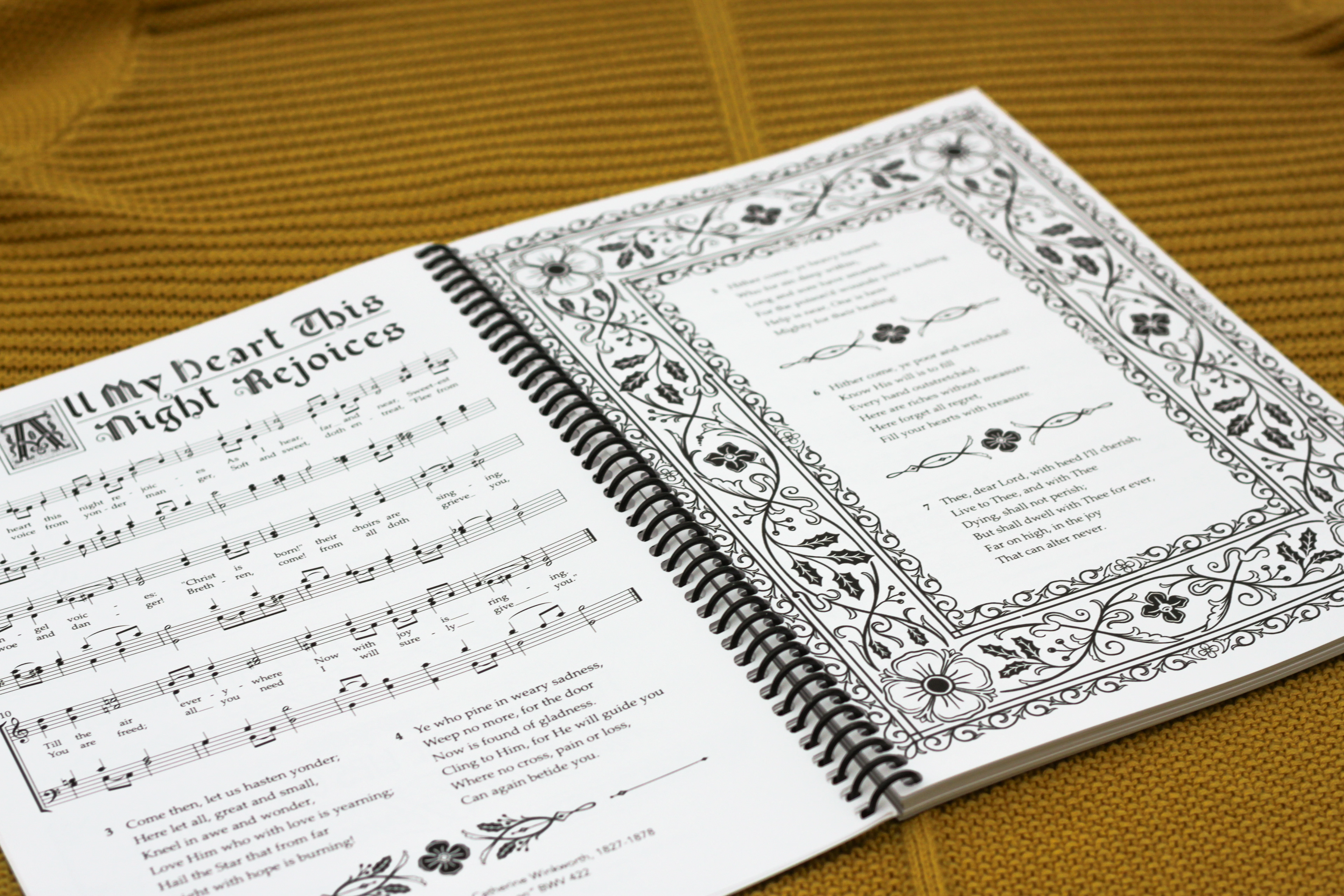 interior graphics on the spread for "All My Heart This Night Rejoices," including title treatment, facing page illustrations and florals to finish