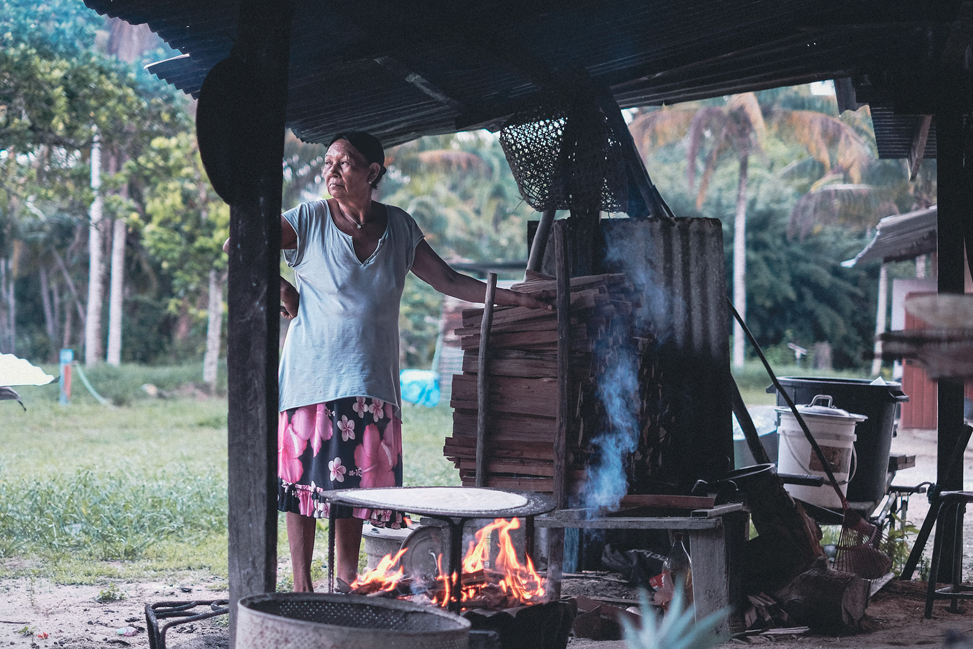 Richele Sjabere, sous son carbet, surveille la cuisson d’une galette de manioc : la cassave