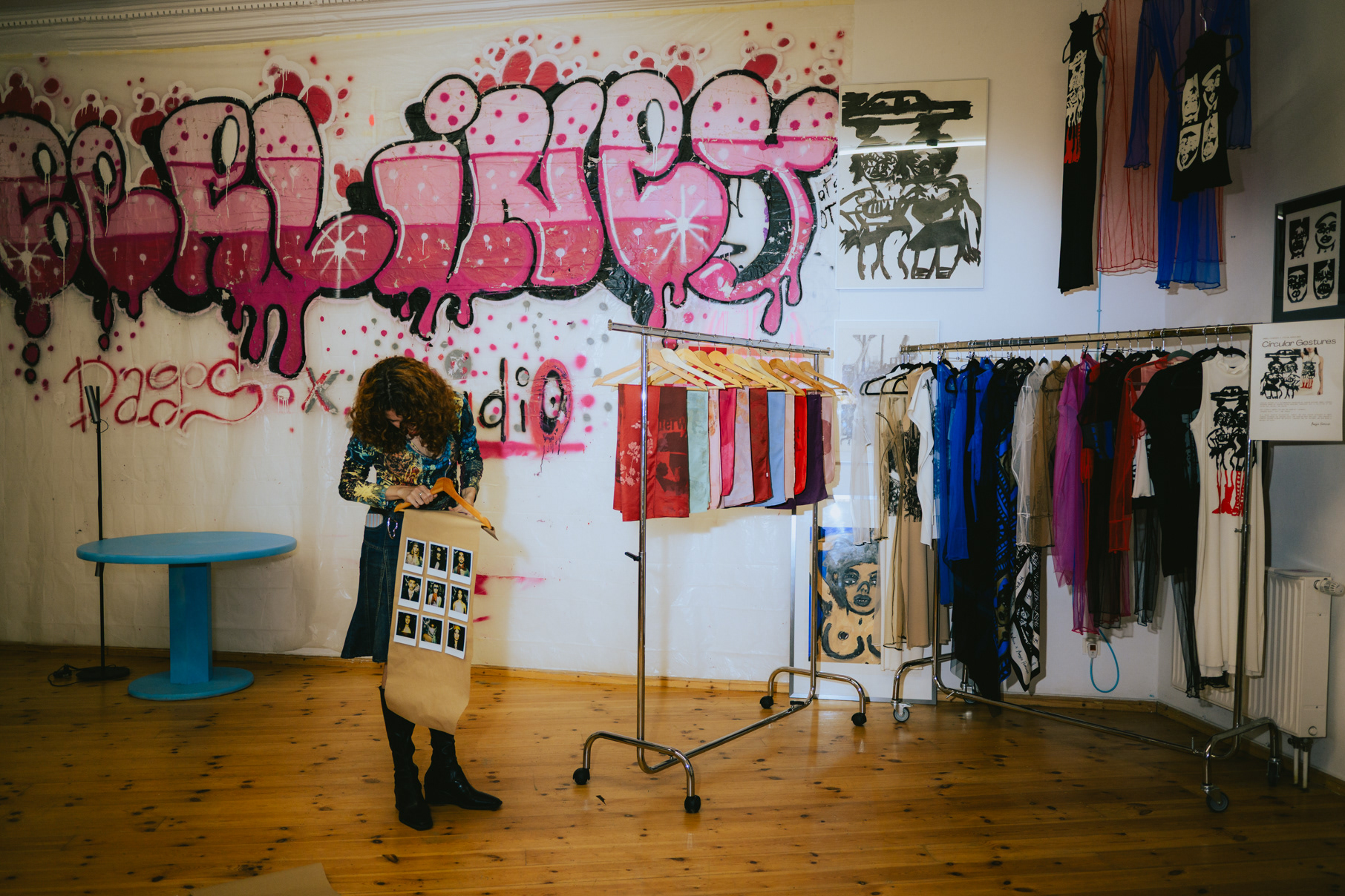 Backstage dressing area with graffiti wall and clothing rack at a Berlin fashion event