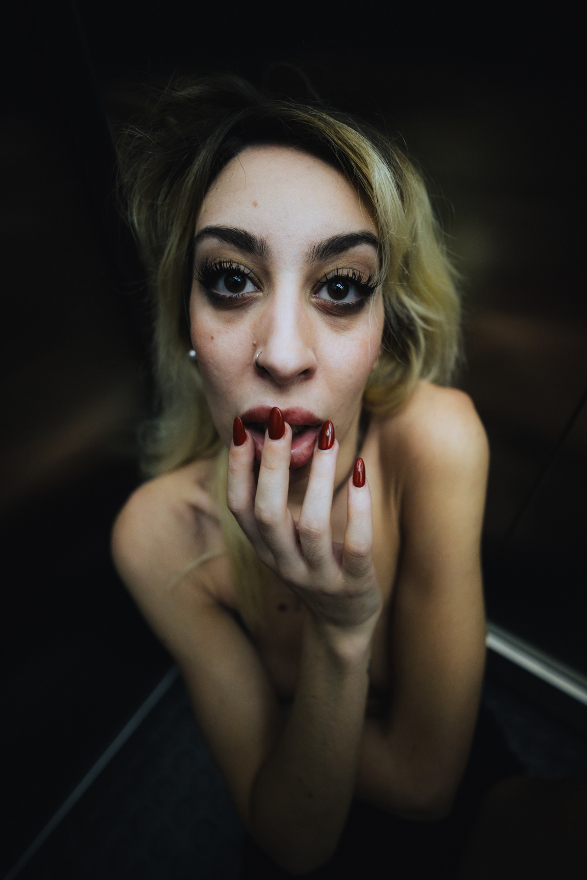 Close boudoir portrait with bold makeup in low light in Bangkok