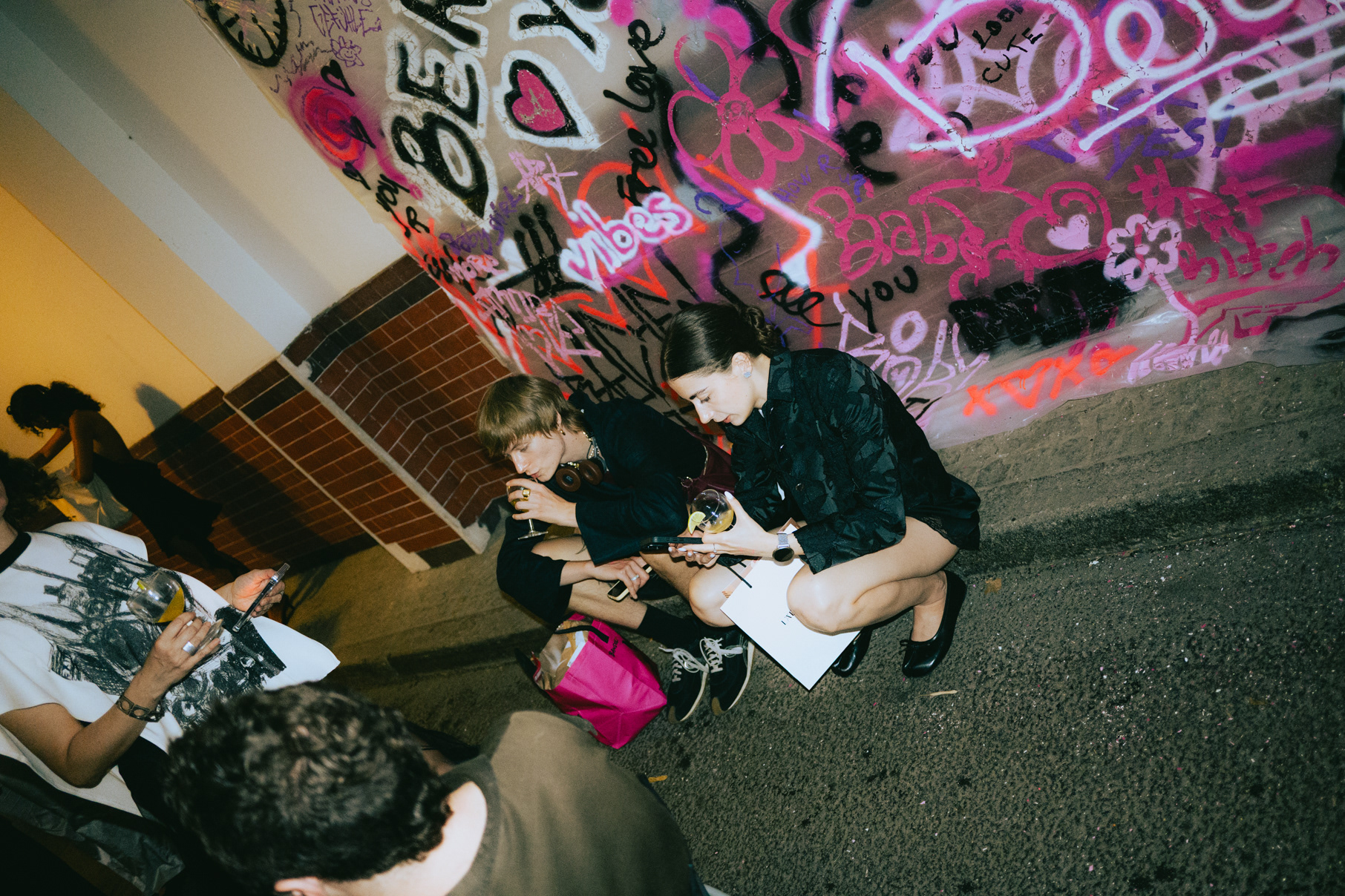 Guests reviewing photos together against a graffiti wall at a Berlin fashion event