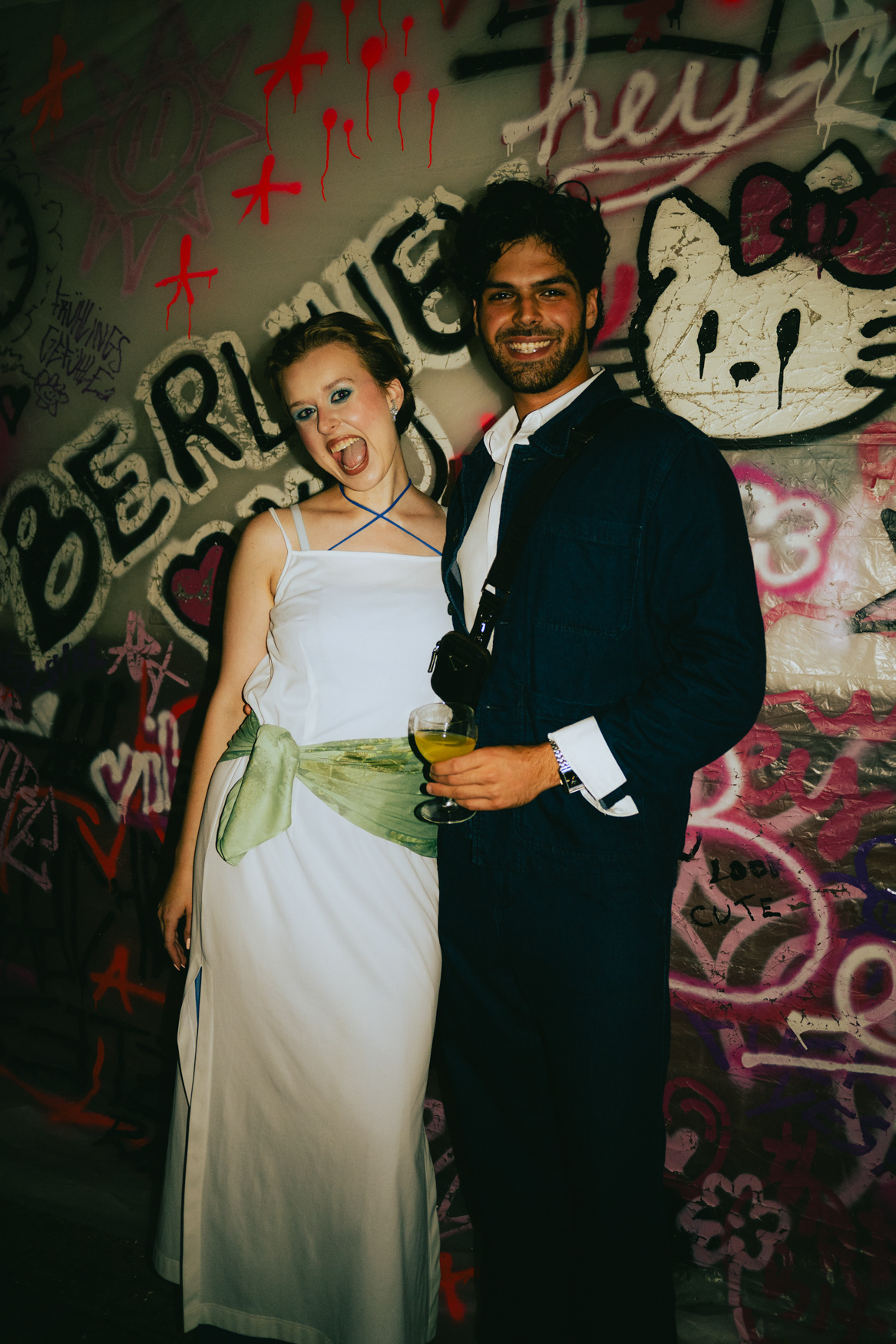 Elegant couple posing together in black outfits at a Berlin fashion event