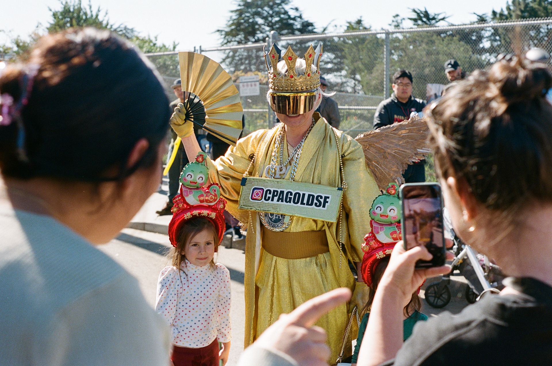A little girl poses with @CPAGoldSF at the Lunar New Year celebration at the Outer Sunset Farmers Market on Feb. 9, 2025. Photo by Klyde Java.