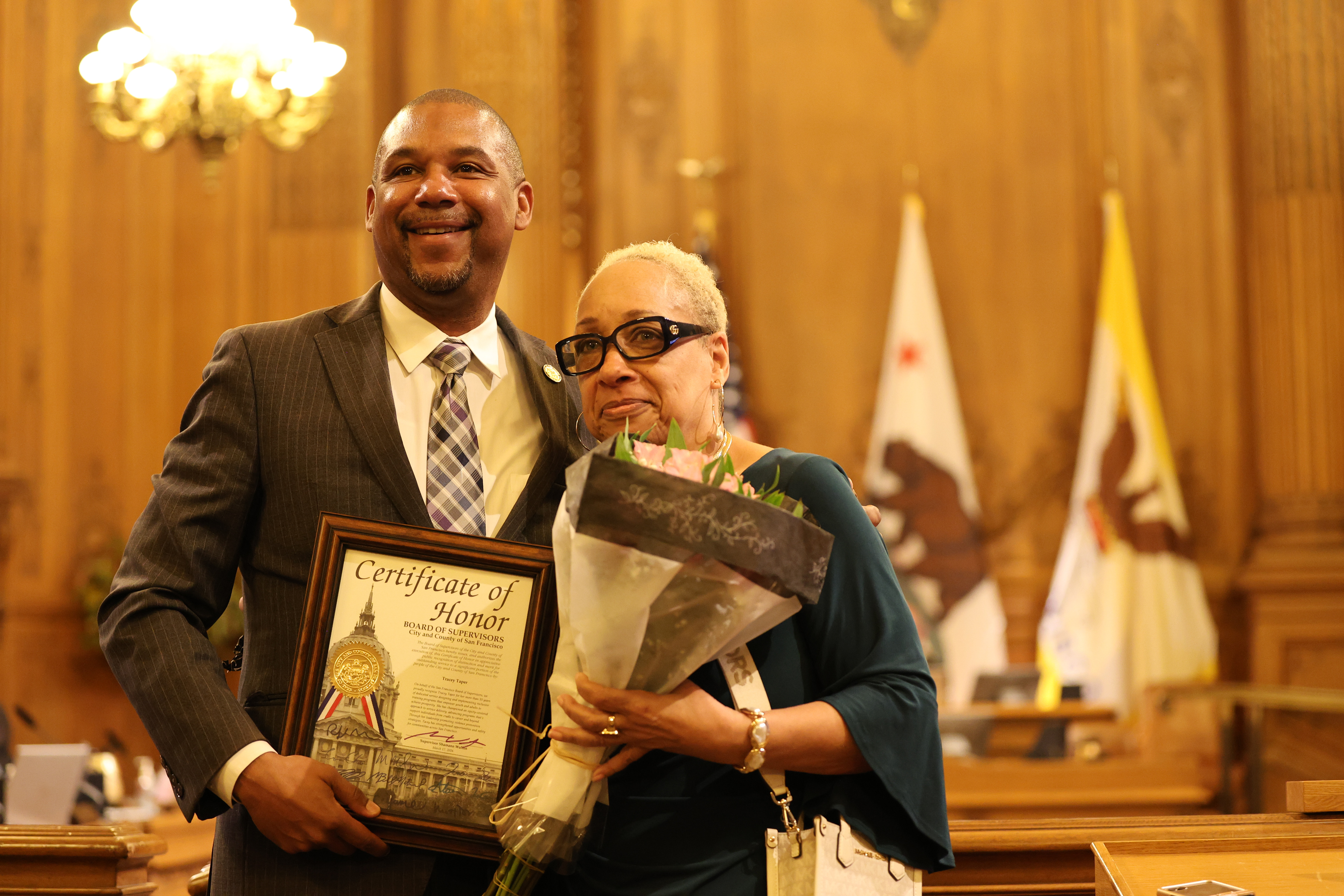 San Francisco District 10 Supervisor Shamann Walton honors educator Tracey Taper during a board of supervisors meeting on March 17, 2026. Photo by Klyde Java.