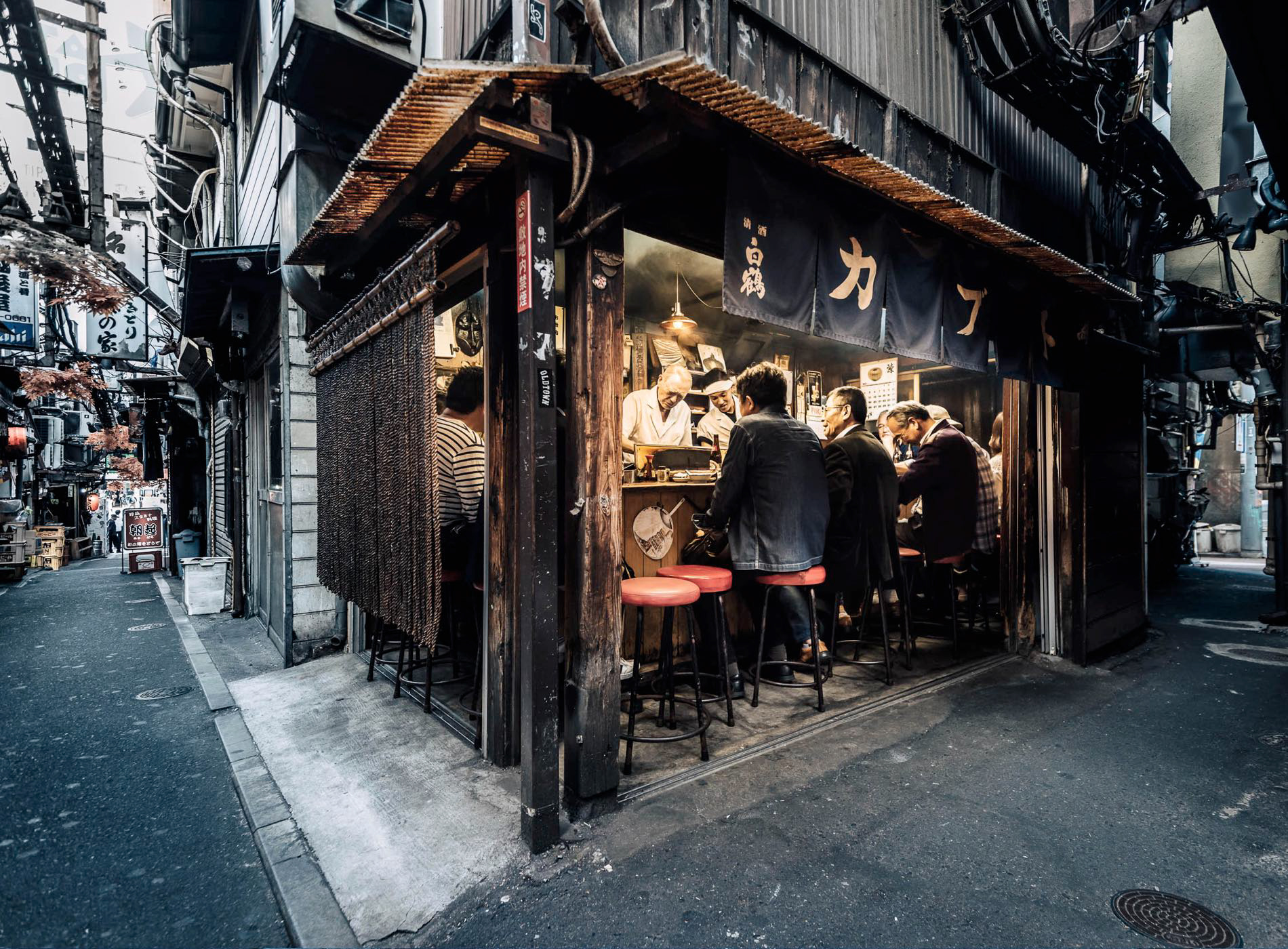 In the early evening, customers enjoy a selection of grilled 'unagi' eel items at Kabuto, an izakaya on Omoide Yokocho in Shinjuku, Shinjuku City, Tokyo, Japan