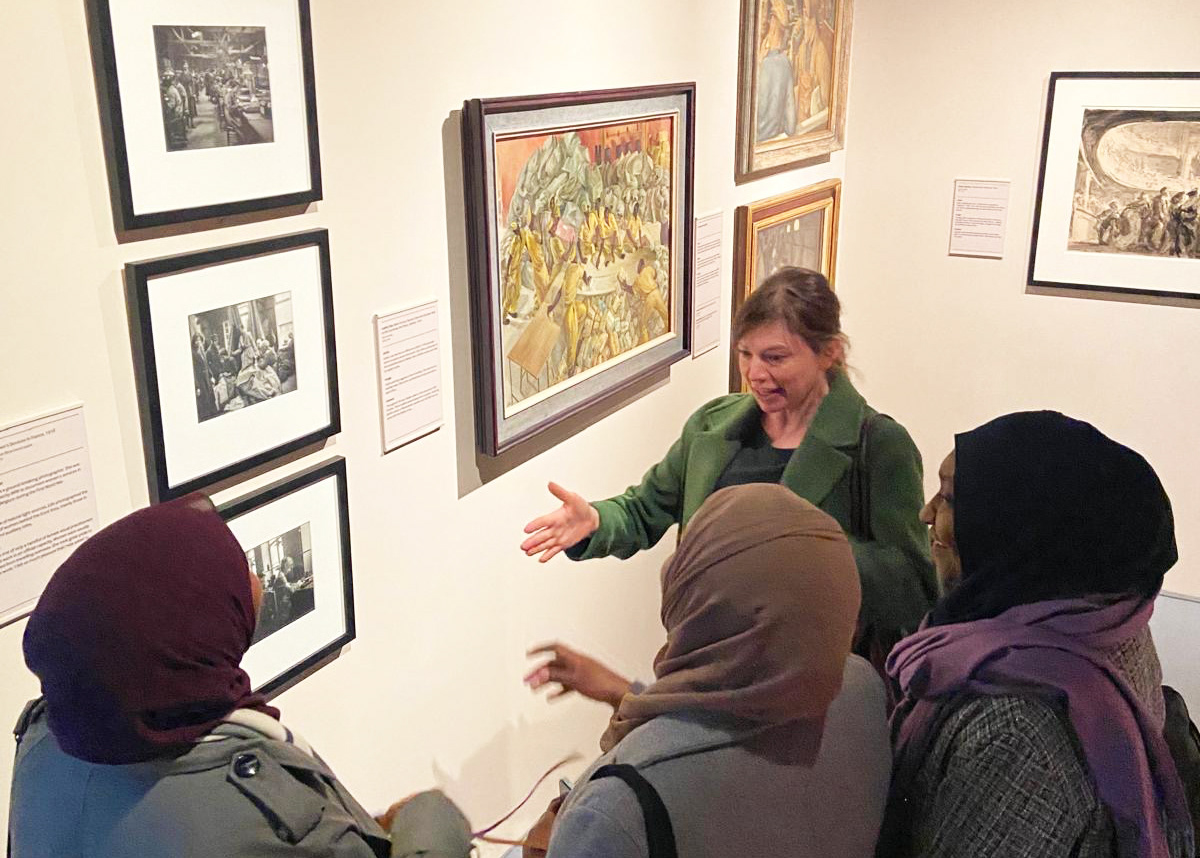 Dr Pippa Oldfield with Ethar and Mayas Dirar and Arafa Gouda at Imperial War Museum. London, discussing photographs of women's war work by Olive Edis