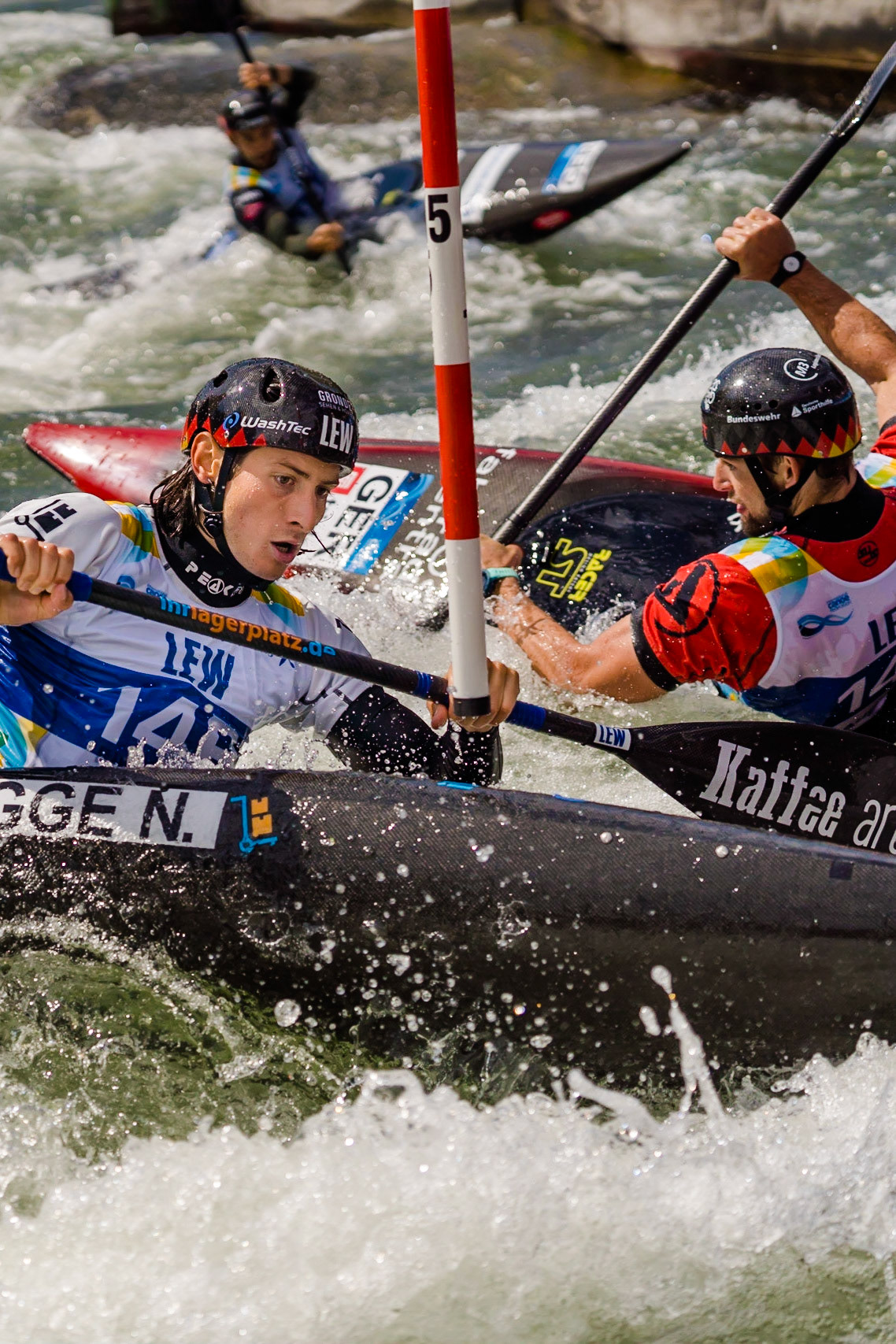 Noah Hegge, Stefan Hengst, Hannes Aigner, Goldmedaillengewinner im Herren Kajak Mannschaftsrennen. Kanuslalom WM 2022 in Augsburg, Deutschland. 50 jähriges Jubiläum der Olympiastrecke am Eiskanal. / 2022 ICF Canoe Slalom World Championships. Foto: Birke Oud/www.birkeoud.com