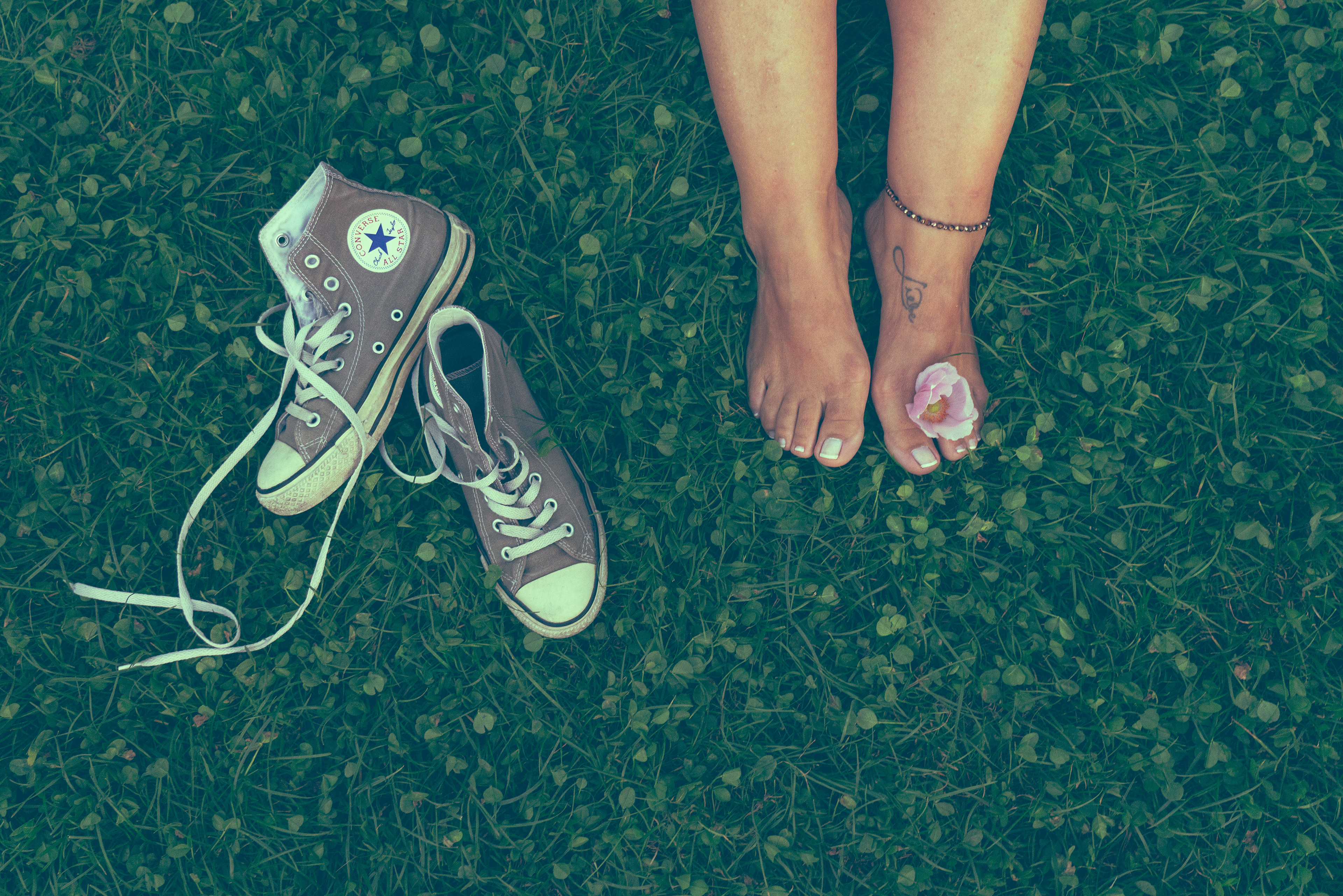 Veronika Rauch - Damenfuesse mit Blume und Schuhen im Gras