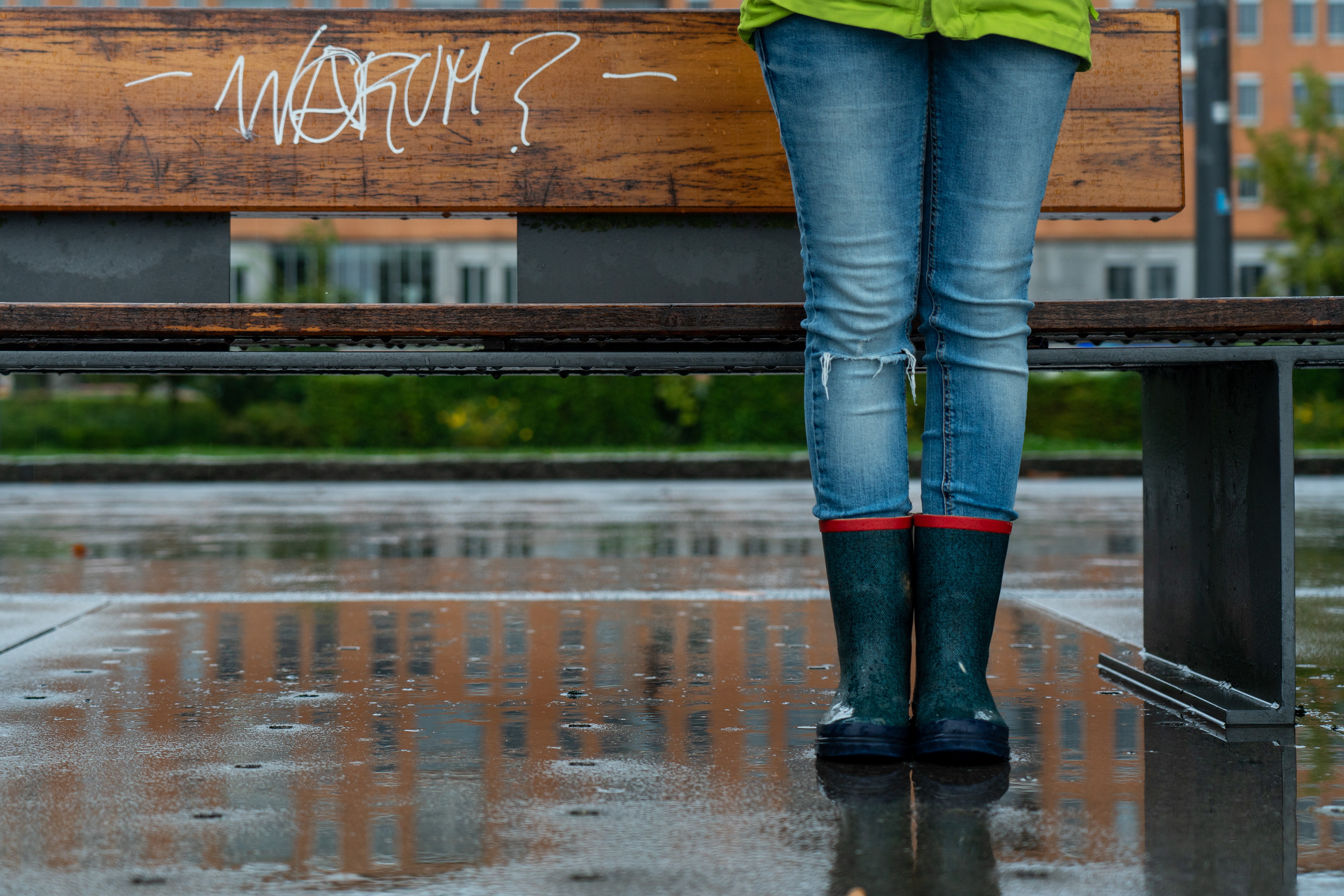 Veronika Rauch - Maedchen mit Gummistiefel im Regen vor Bank