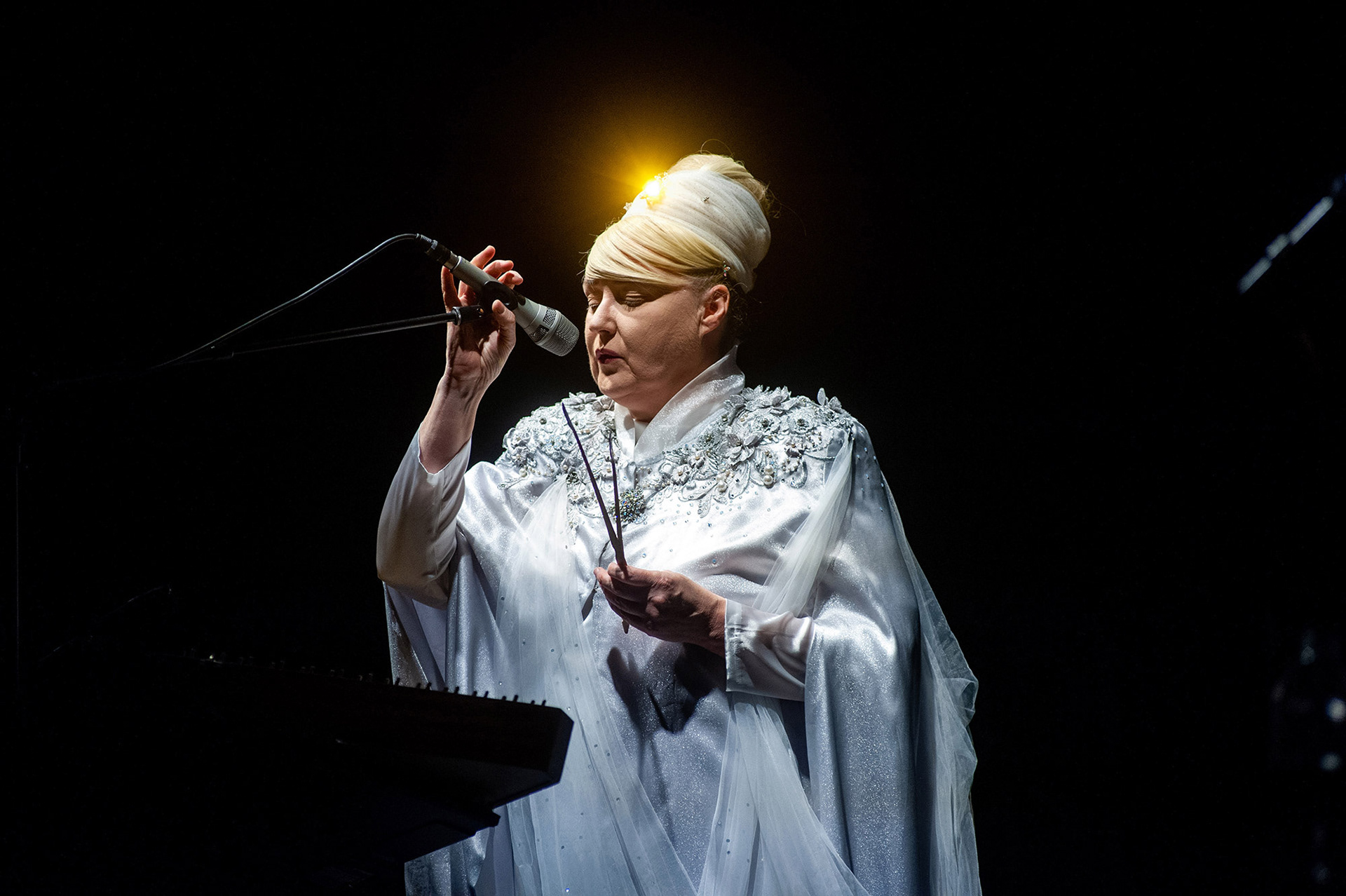 Υποβλητικό close-up της Lisa Gerrard με δραματικό οπίσθιο φωτισμό που δημιουργεί ένα λαμπερό φωτοστέφανο στα μαλλιά της - Evocative close-up of Lisa Gerrard with dramatic rim lighting creating a glowing halo effect around her hair