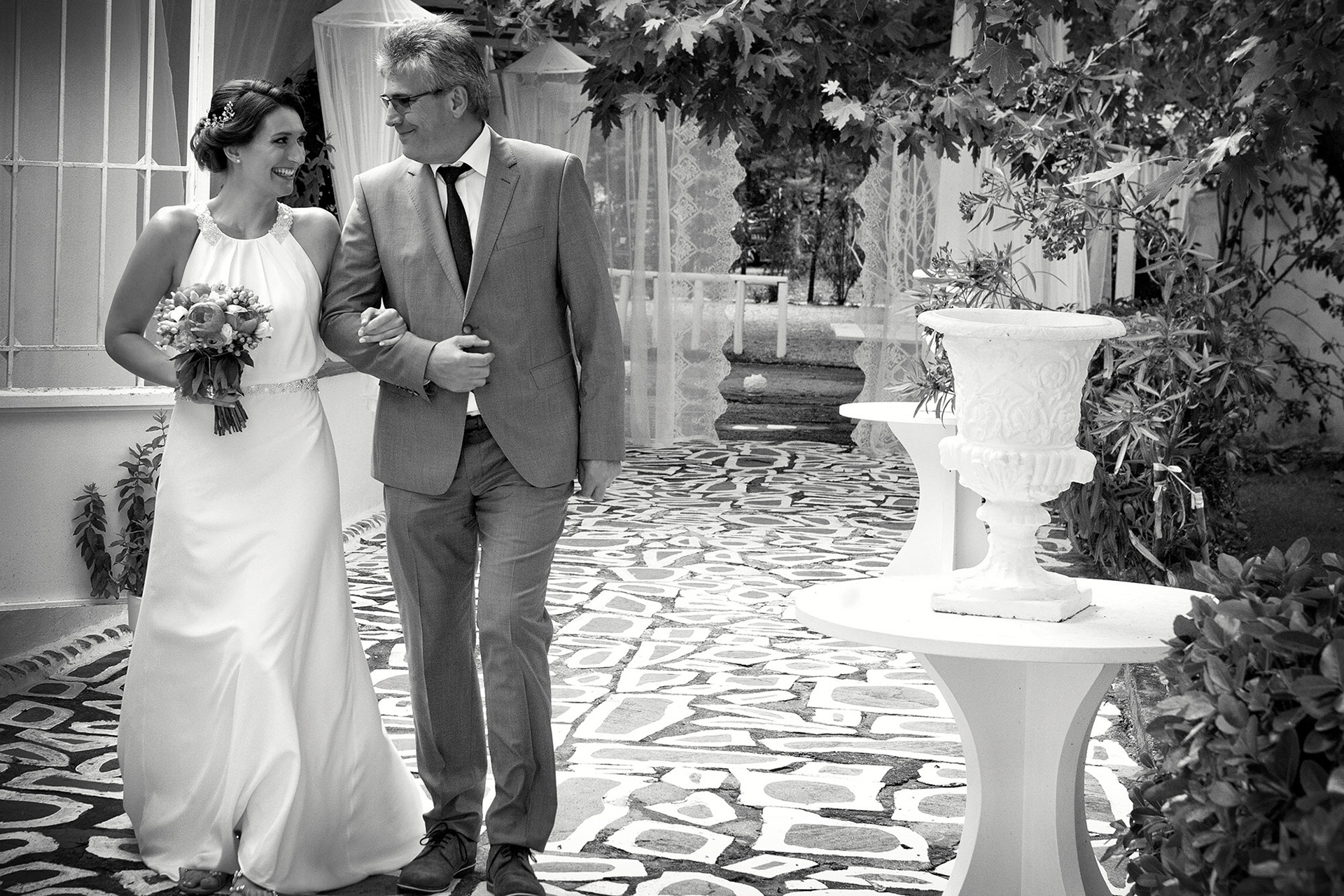 Η νύφη και ο πατέρας της περπατούν χαμογελαστοί προς την τελετή του γάμου στο Λιτόχωρο.   The bride and her father walking joyfully toward the wedding ceremony in Litochoro.