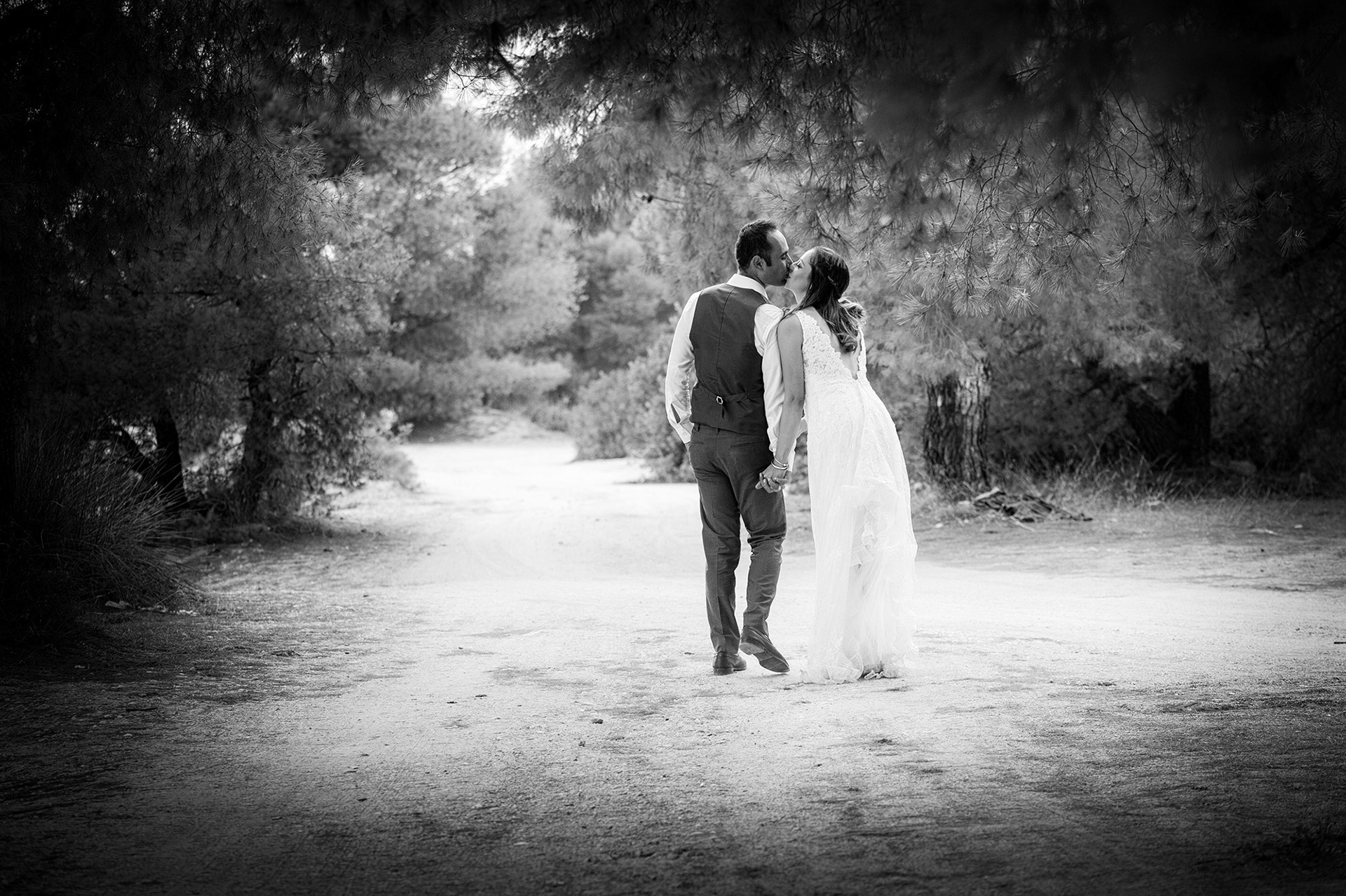 Το ζευγάρι περπατά και φιλιέται σε αυθόρμητη στιγμή σε παραλιακό τοπίο στη Χαλκιδική- φωτογράφηση next day γάμου, The couple walks and kisses in a spontaneous moment in a coastal landscape in Halkidiki - next day wedding photoshoot