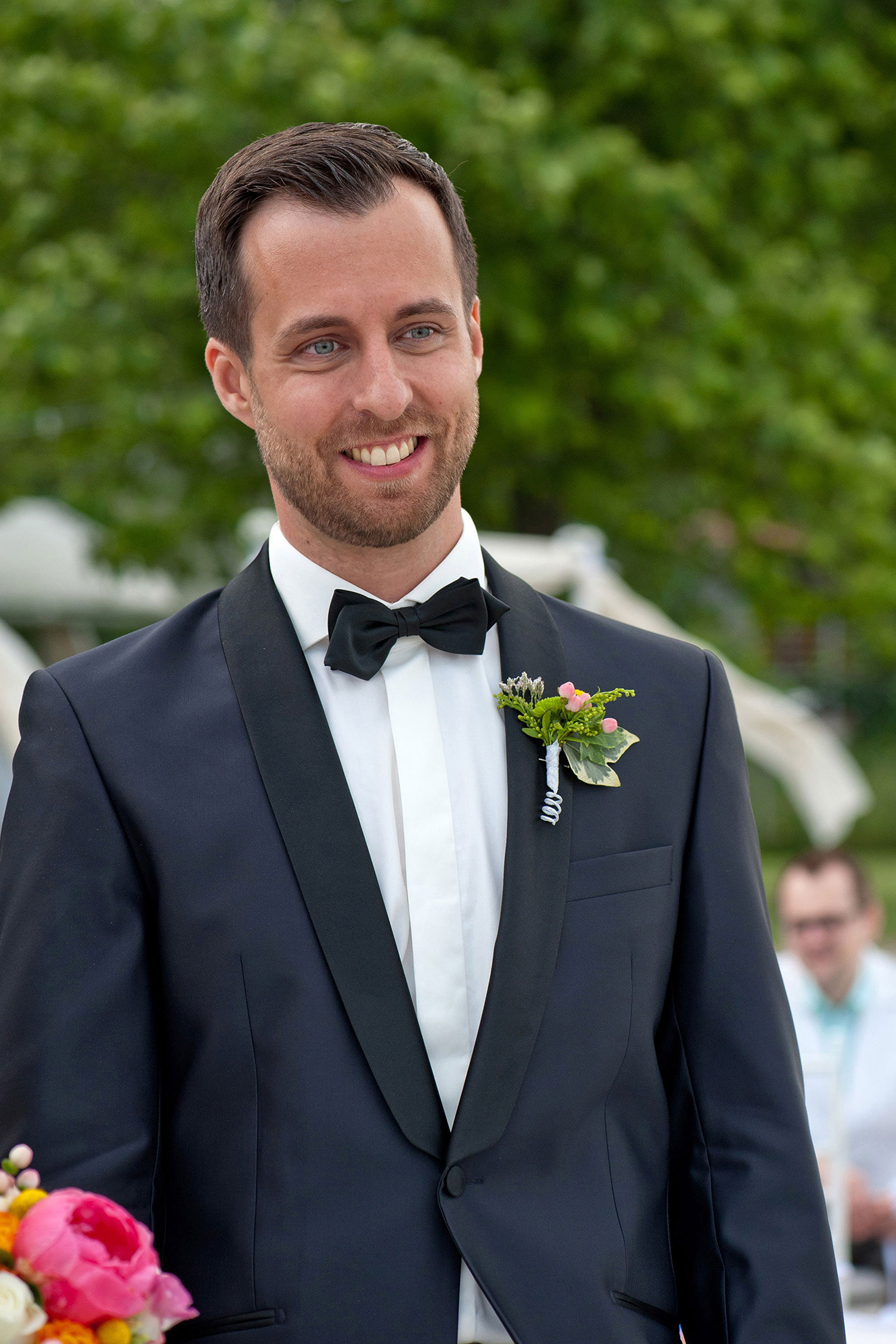 Ο γαμπρός χαμογελά συγκινημένος κατά τη διάρκεια της τελετής του γάμου. The groom smiling warmly during the wedding ceremony.