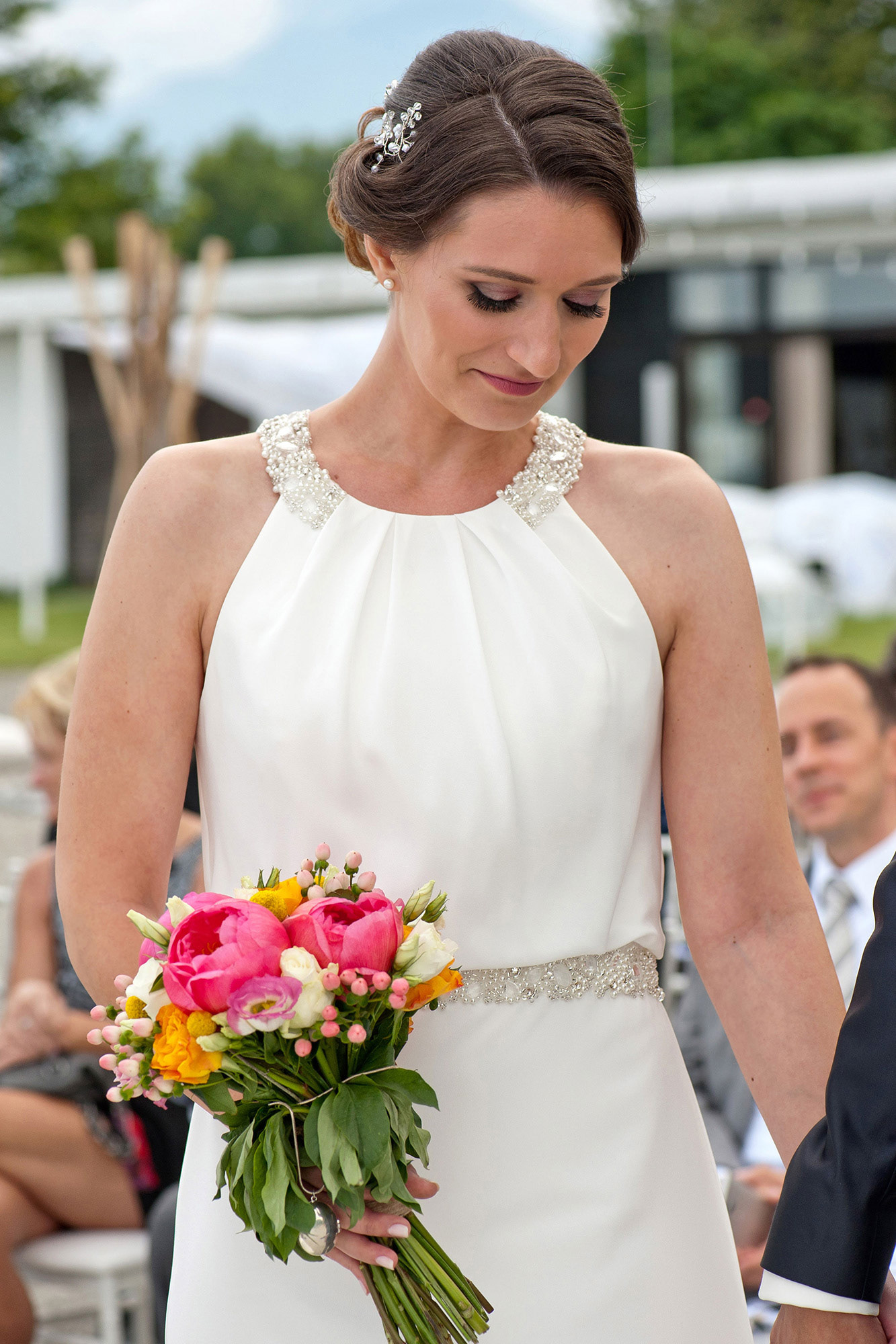 Πορτρέτο της νύφης με την πολύχρωμη ανθοδέσμη της κατά τη διάρκεια της τελετής. Portrait of the bride holding her colorful bouquet during the ceremony.