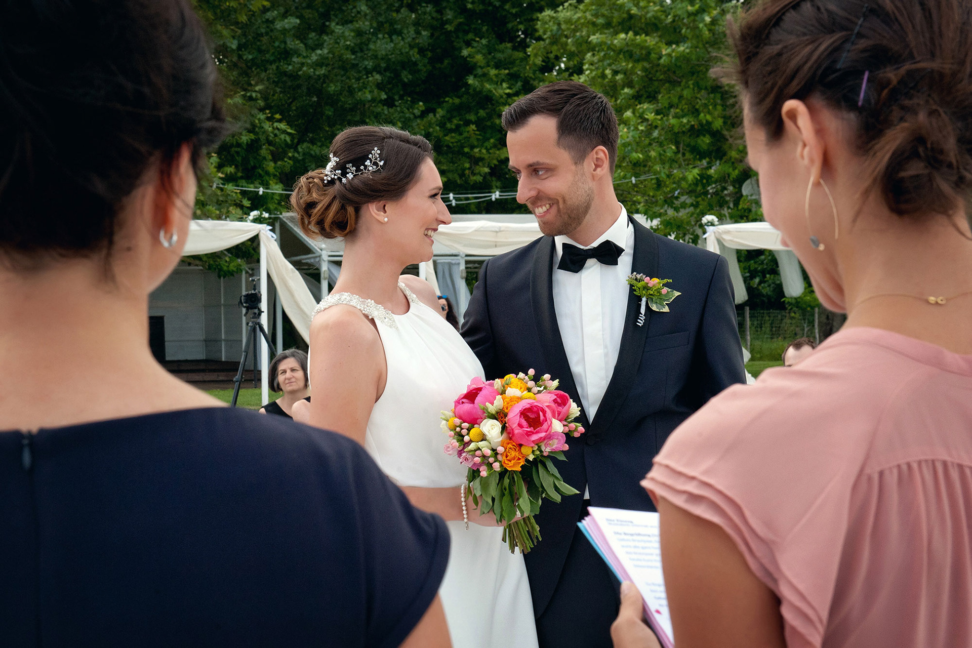 Η νύφη και ο γαμπρός κοιτάζονται συγκινημένοι την ώρα που διαβάζουν τους όρκους τους.    The bride and groom gazing emotionally at each other while reading their vows.