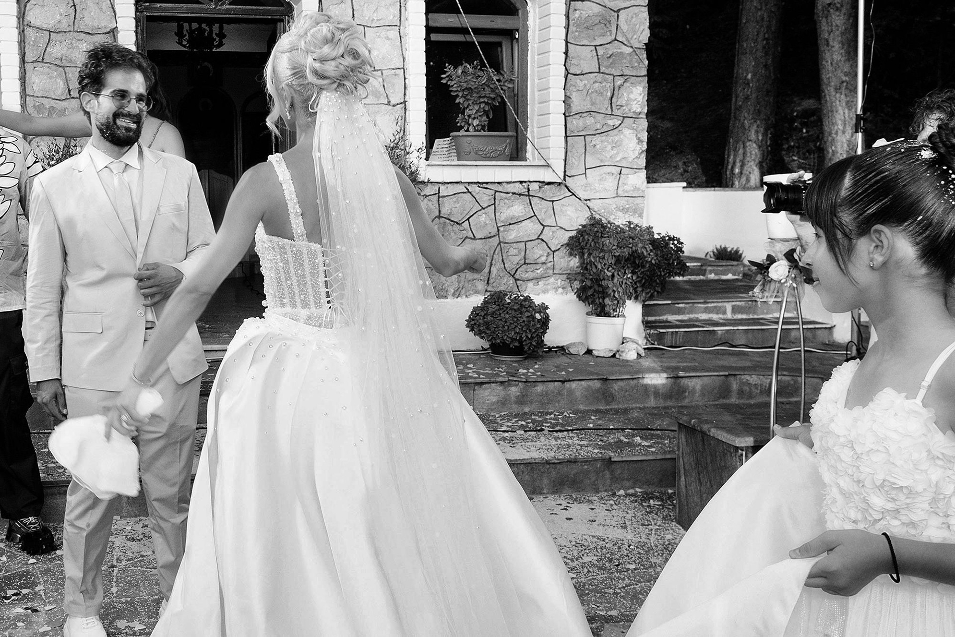 στιγμιότυπο σε ασπρόμαυρη φωτογραφία σε φωτογράφηση γάμου στη θεσσαλονίκη στο τέλος της τελετής με το ζευγάρι να χαμογελάει, black and white photo snapshot from a wedding photoshoot in Thessaloniki at the end of the ceremony with the couple smiling